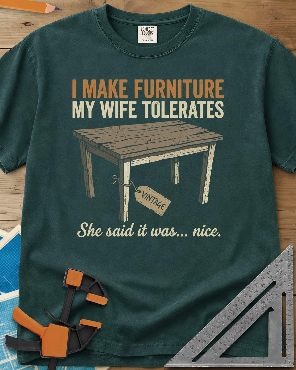 She Said It Was Nice heavyweight tee in Blue Spruce, a weathered rustic table with a VINTAGE tag tied to one leg