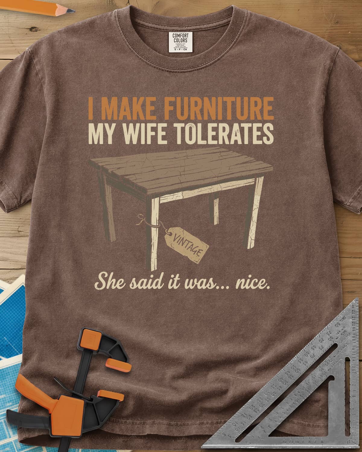 She Said It Was Nice heavyweight tee in Espresso, a weathered rustic table with a VINTAGE tag tied to one leg