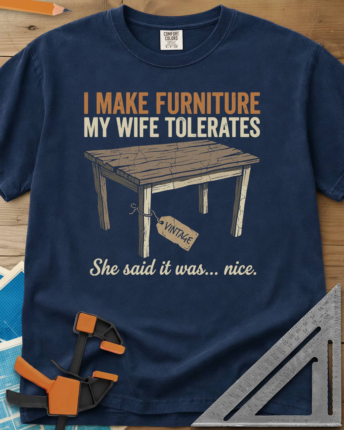 She Said It Was Nice heavyweight tee in Navy, a weathered rustic table with a VINTAGE tag tied to one leg
