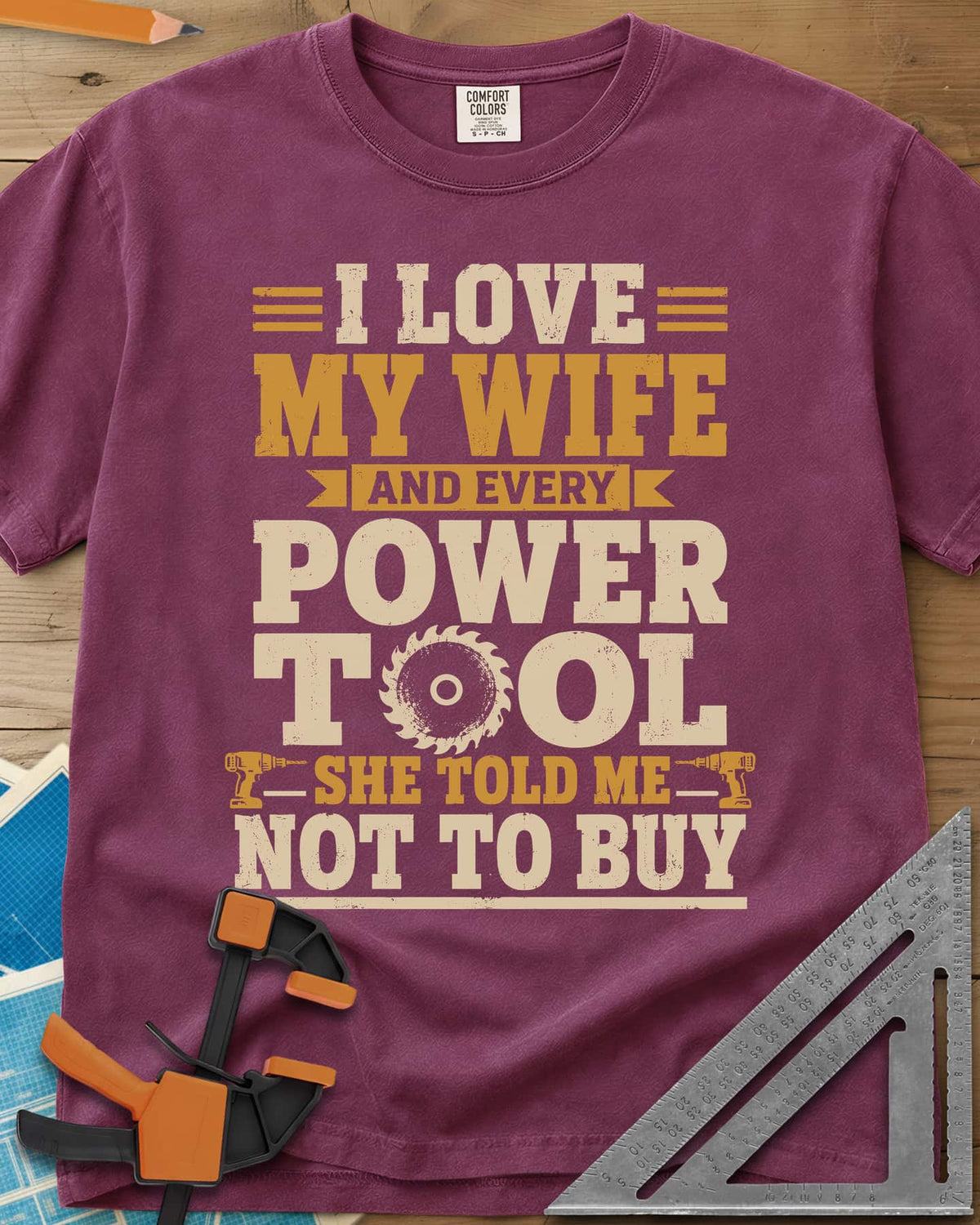She Told Me Not To Buy Power Tools heavyweight tee in Berry, stacked lettering with a saw blade for the O and two cordless