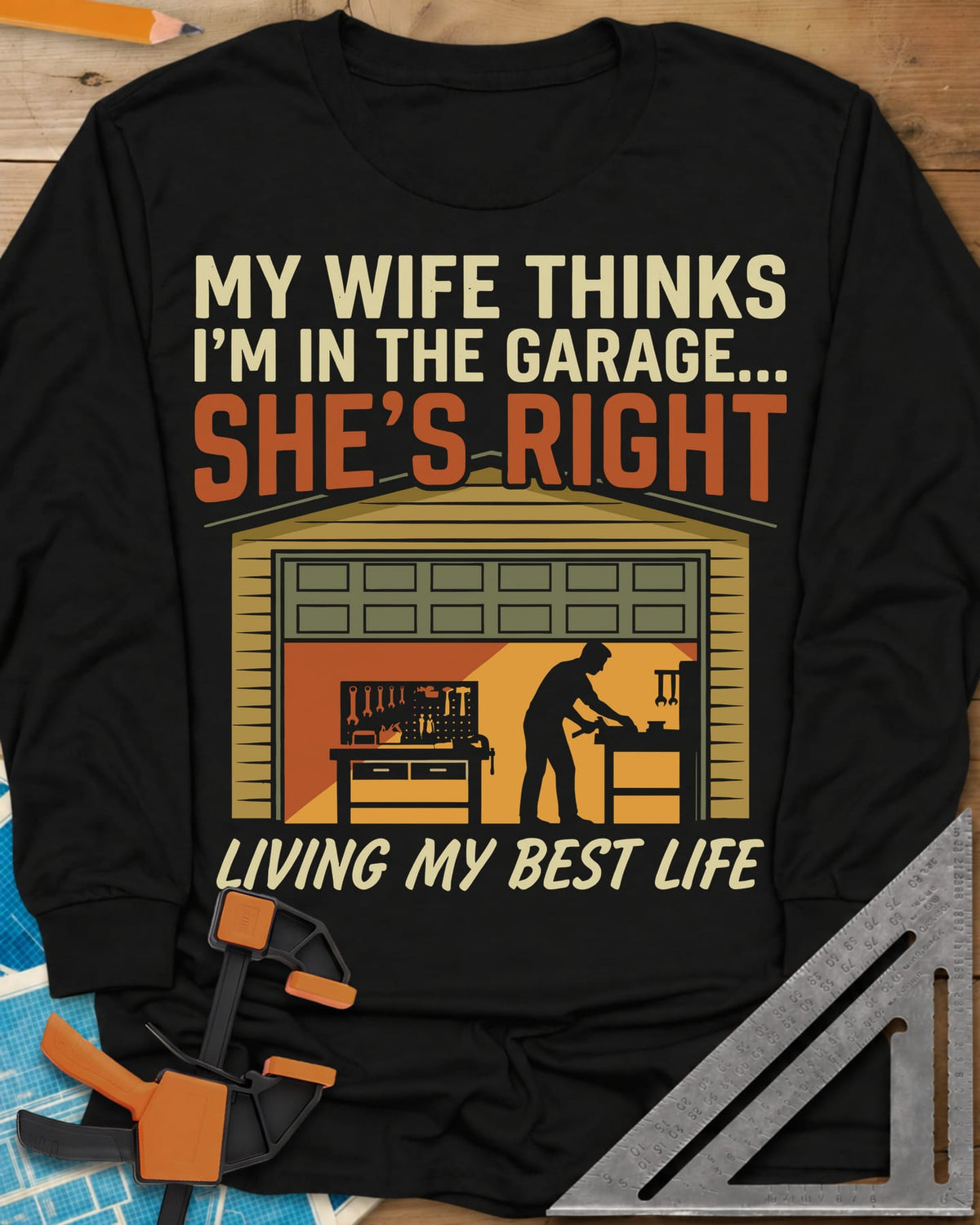 She’s Right long sleeve shirt in Black, a man at his workbench in an open garage, tools on a pegboard