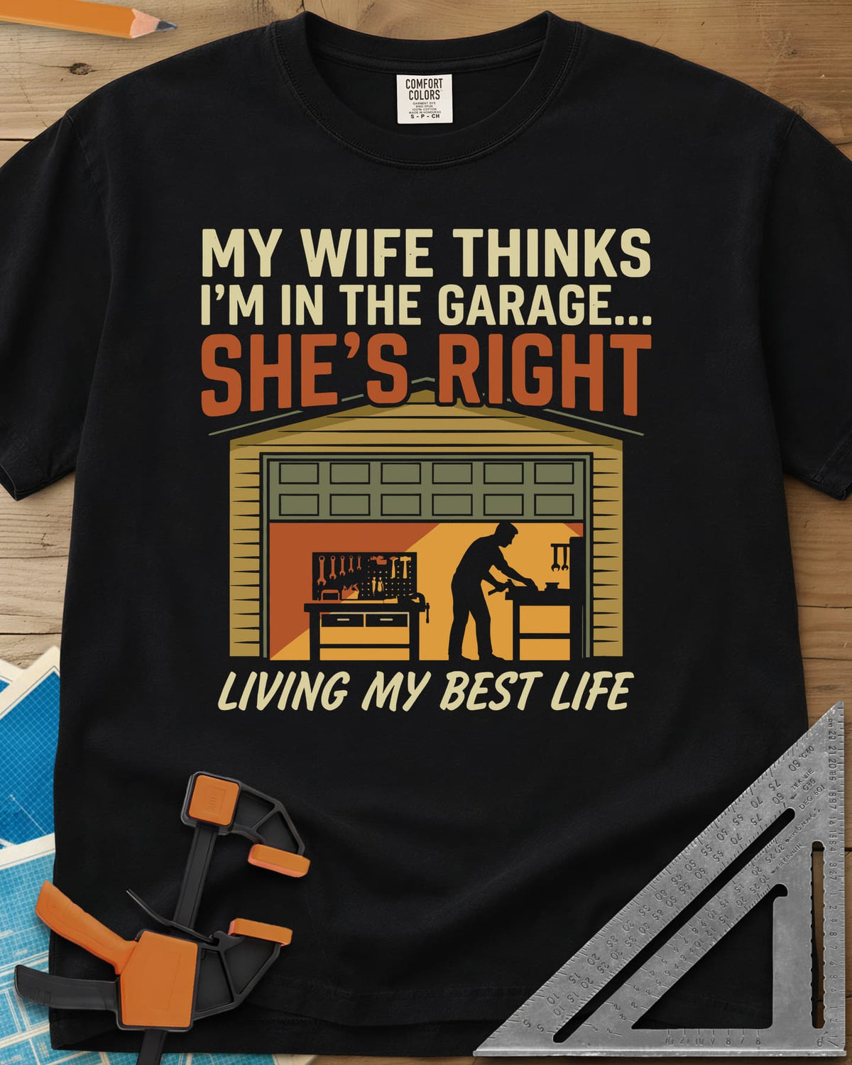 She’s Right heavyweight tee in Black, a man at his workbench in an open garage, tools on a pegboard