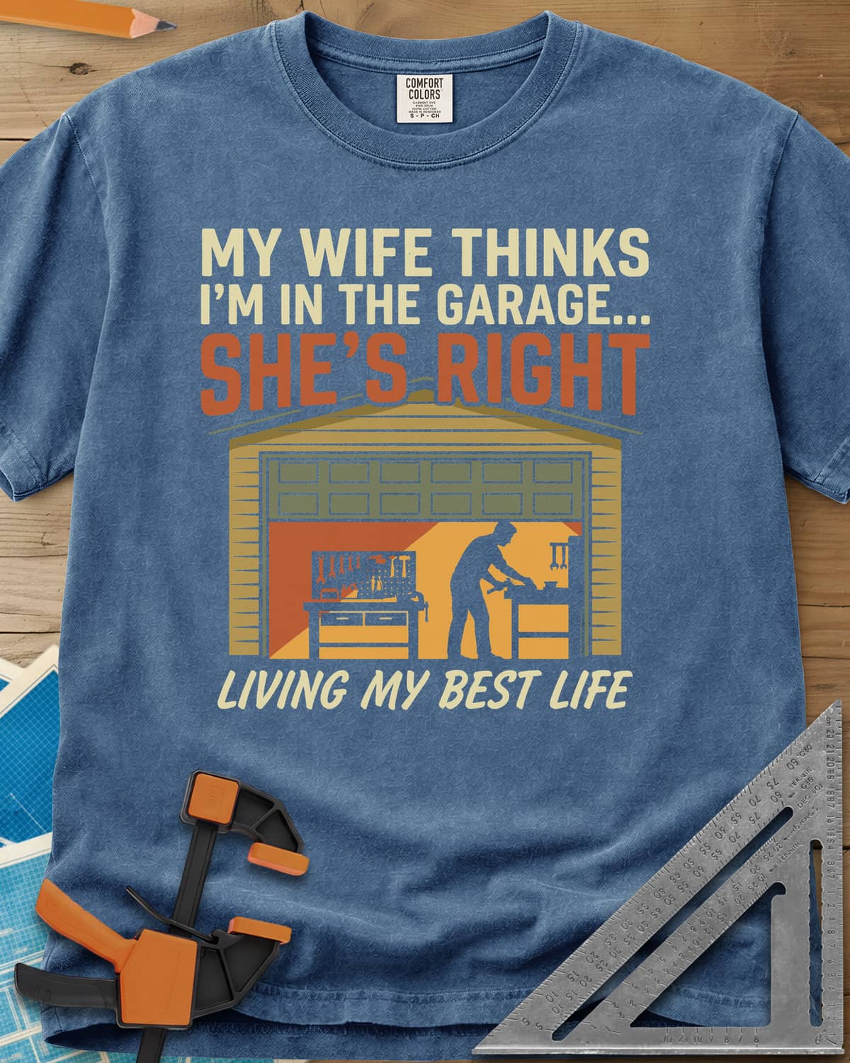 She’s Right heavyweight tee in Blue Jean, a man at his workbench in an open garage, tools on a pegboard