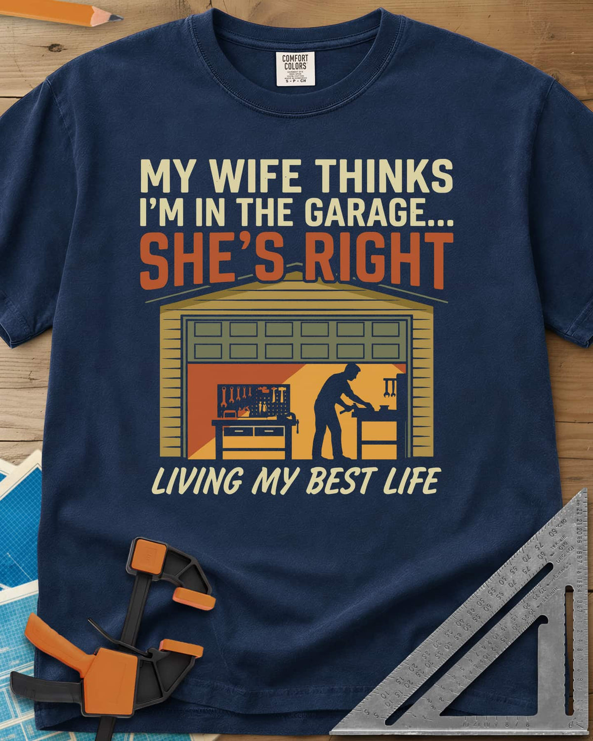 She’s Right heavyweight tee in Navy, a man at his workbench in an open garage, tools on a pegboard