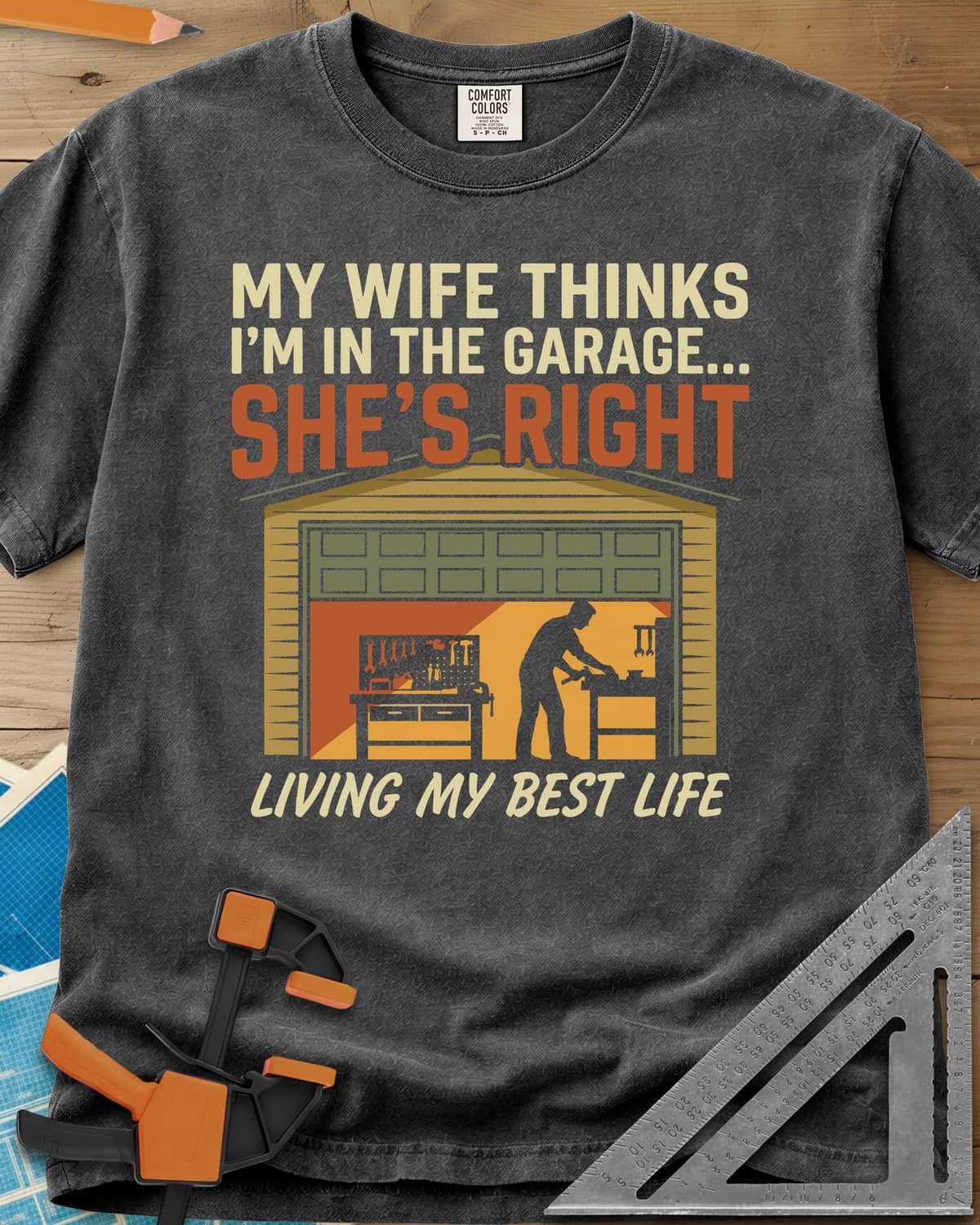 She’s Right heavyweight tee in Pepper, a man at his workbench in an open garage, tools on a pegboard