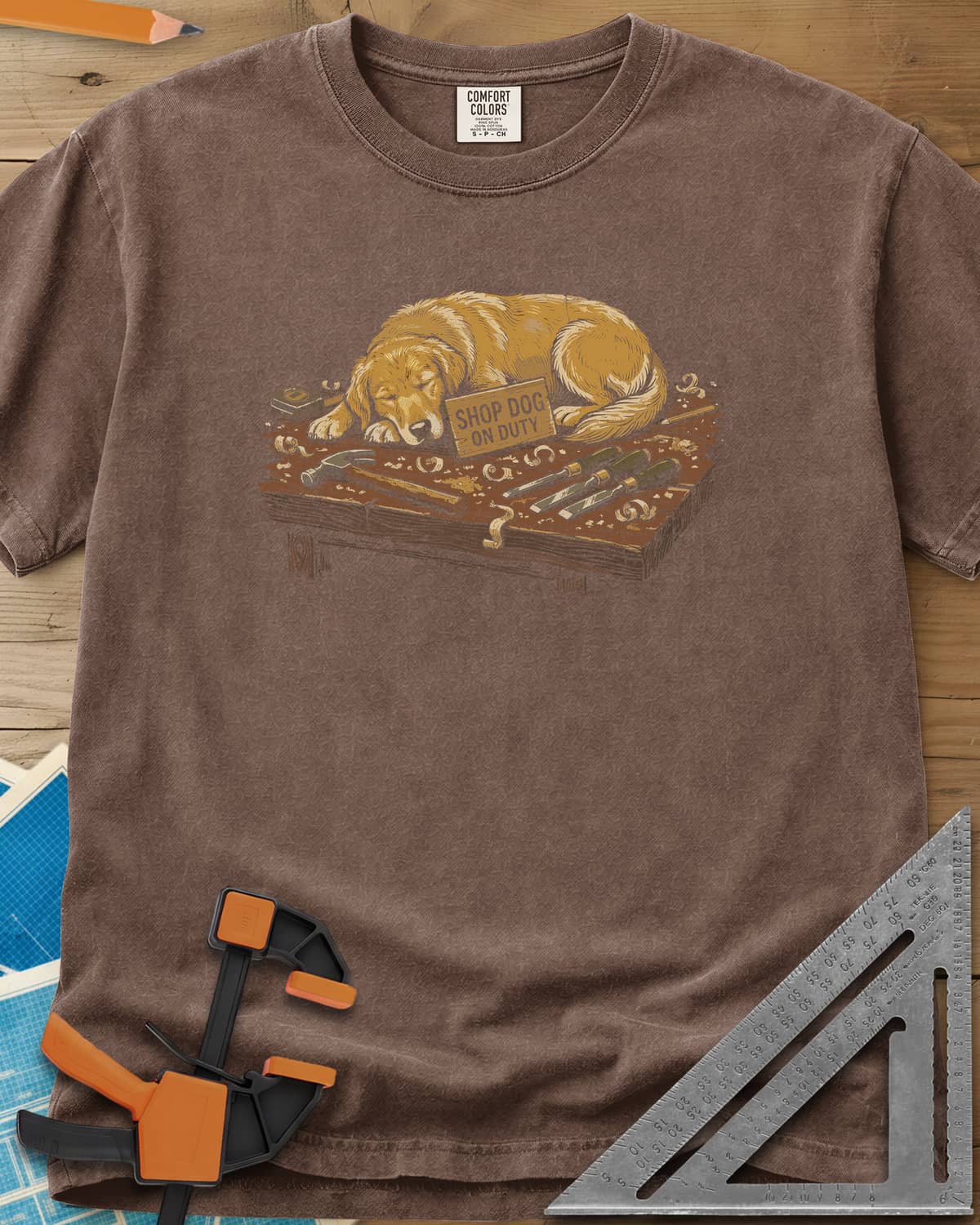 Shop Dog On Duty heavyweight tee in Espresso, a golden retriever asleep on a workbench beside tools and shavings