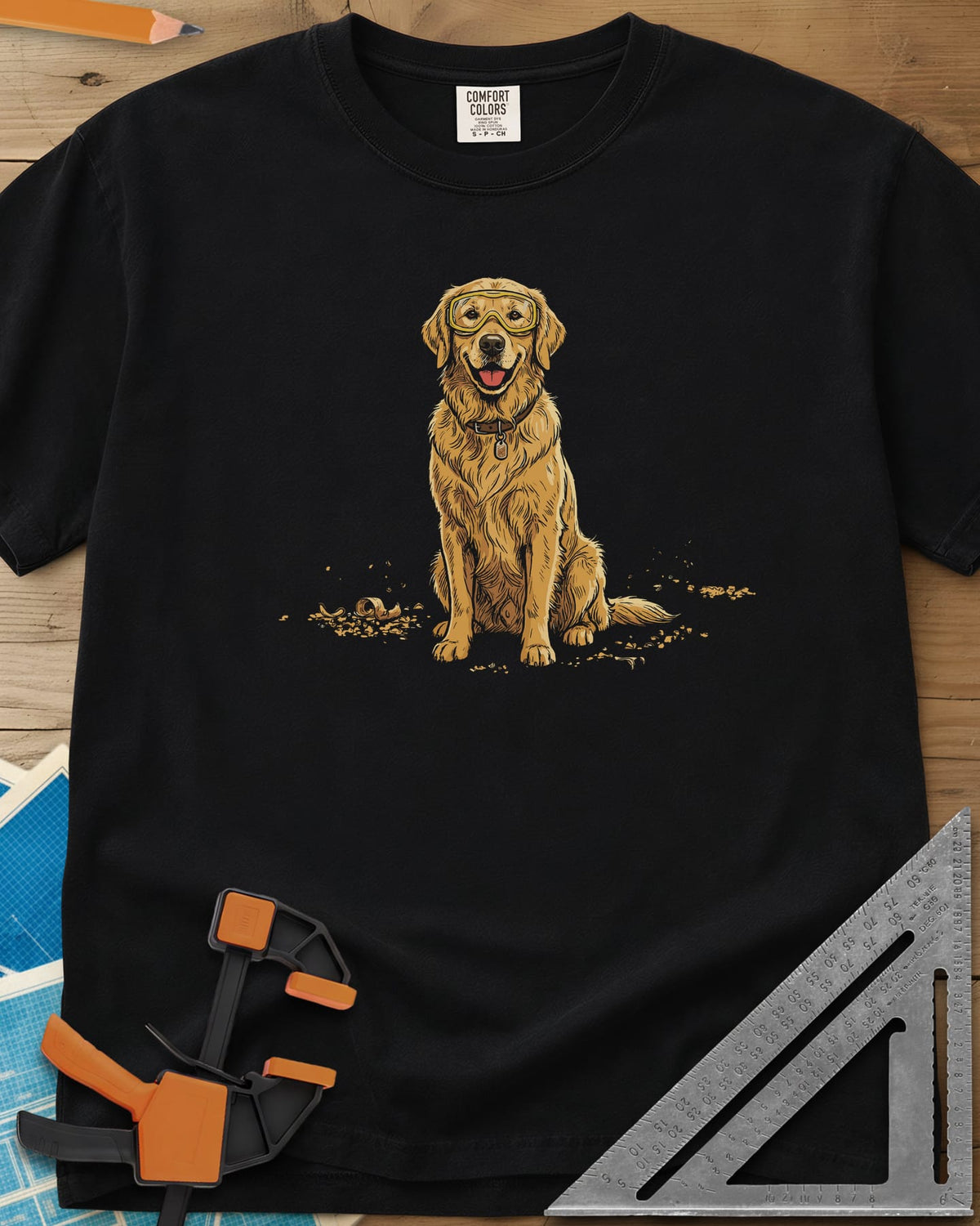 Shop Dog Safety First heavyweight tee in Black, a golden retriever in safety goggles sitting in wood shavings