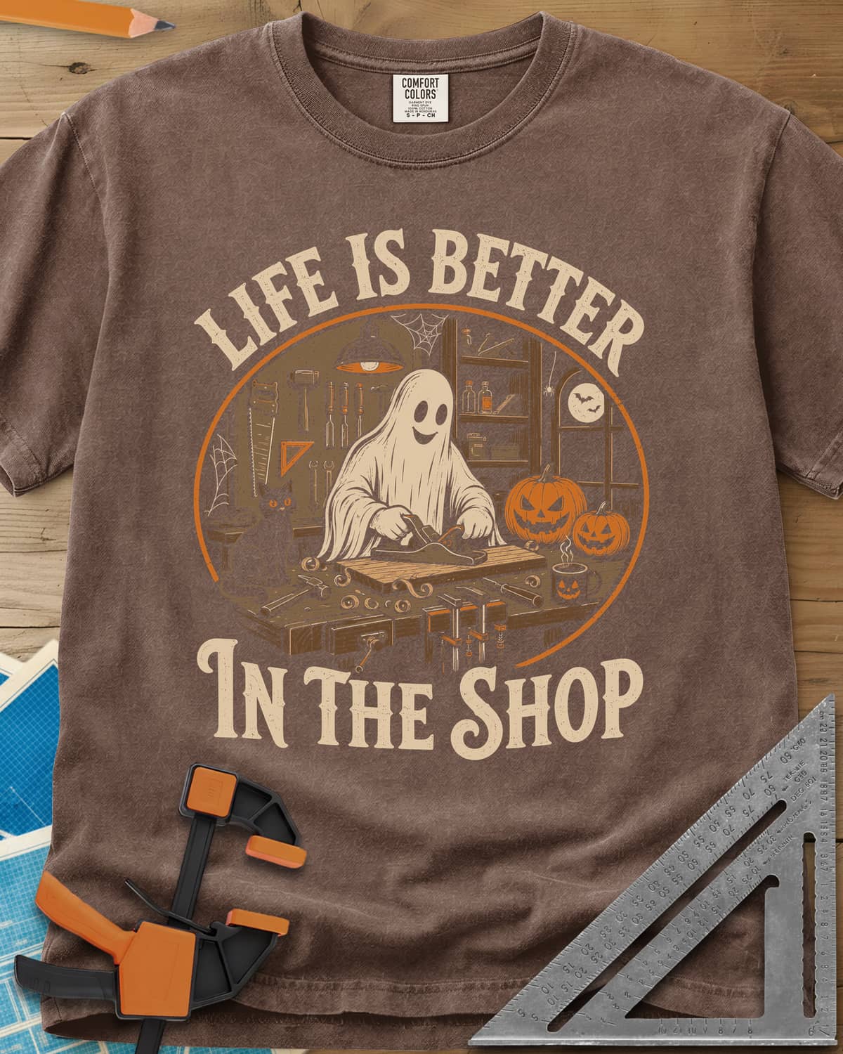 Shop Life heavyweight tee in Espresso, a smiling ghost planing a board beside a cat and pumpkins