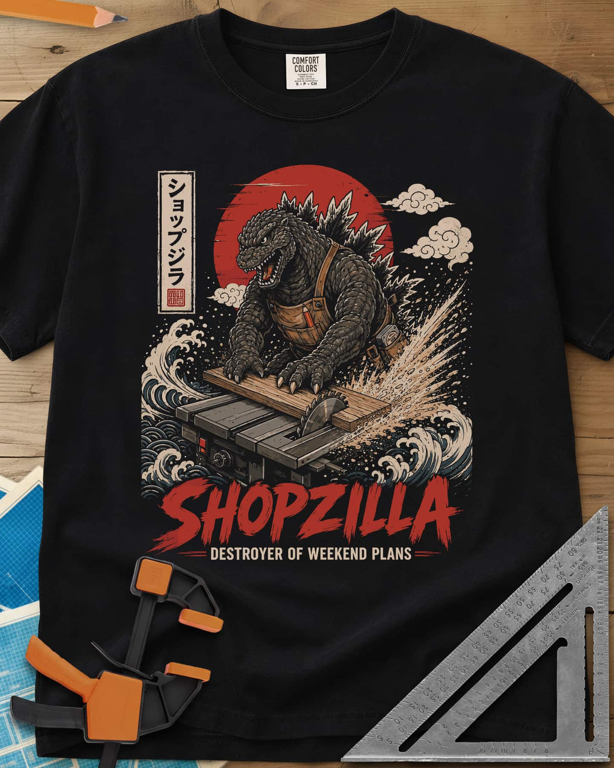Shopzilla heavyweight tee in Black, a monster in a tool apron pushing a board through a table saw