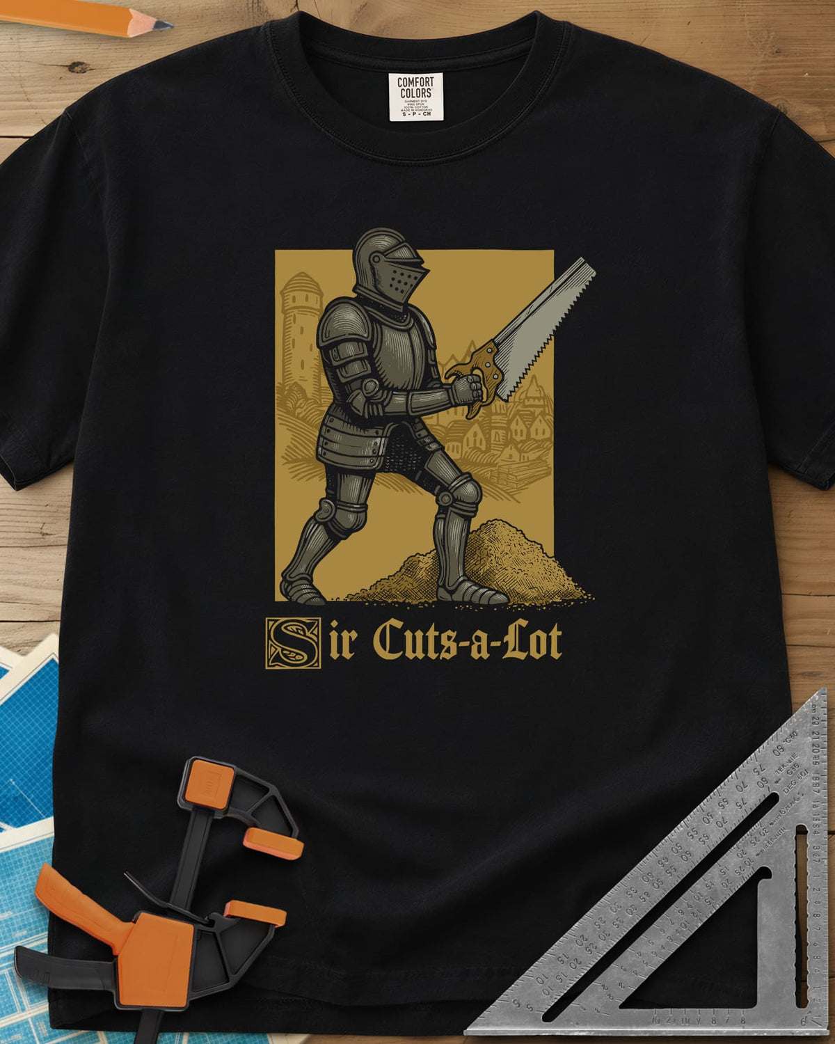Sir Cuts A Lot heavyweight tee in Black, an armored knight with a handsaw and a mound of sawdust