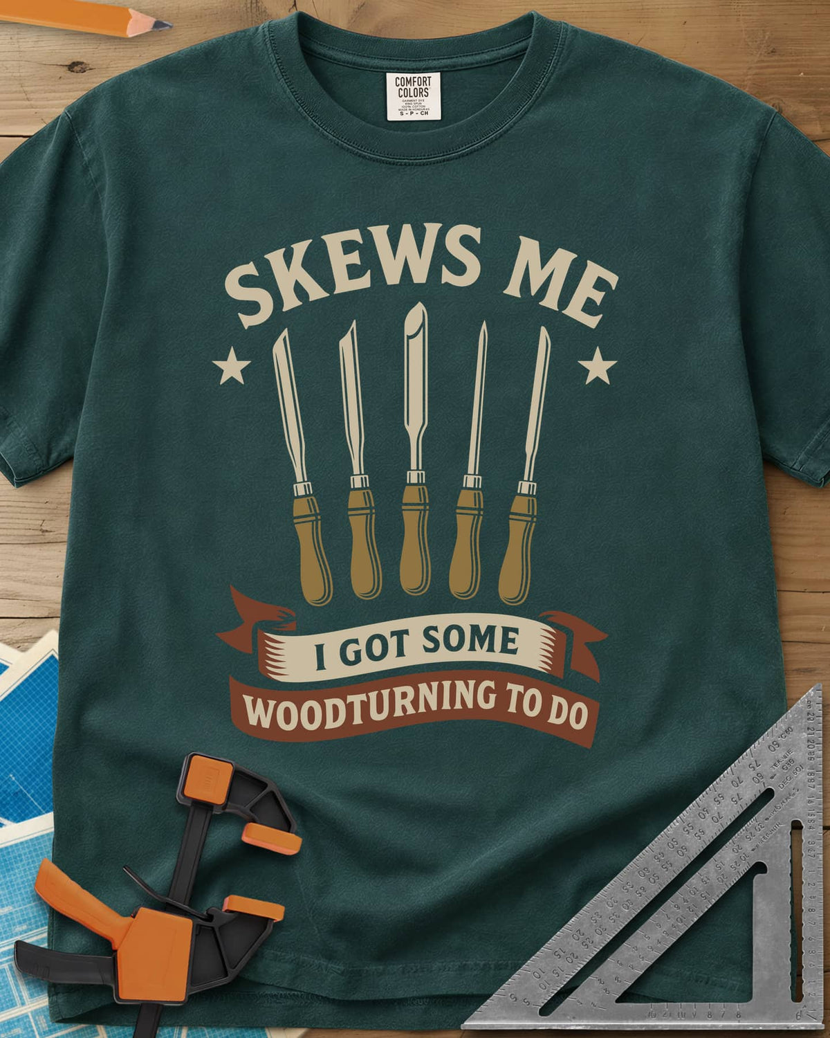 Skews Me heavyweight tee in Blue Spruce, five turning tools between two stars above a ribbon banner