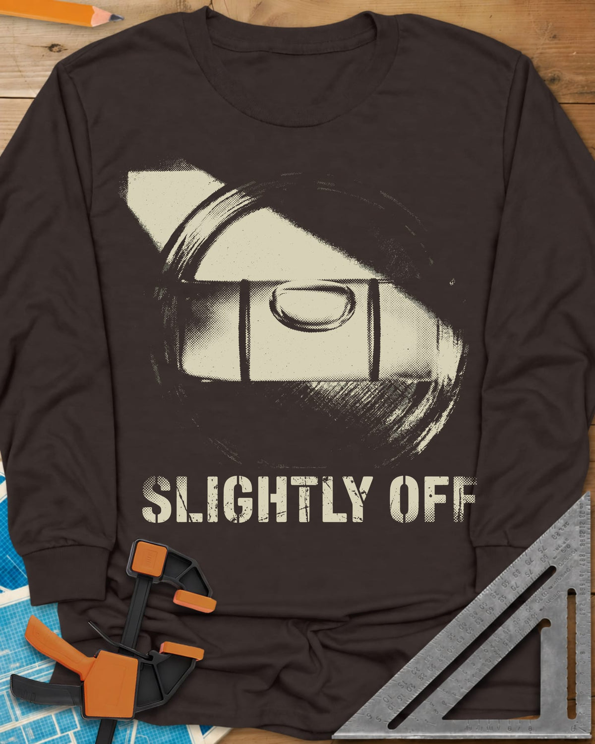 Slightly Off Level long sleeve shirt in Dark Chocolate, a tilted spirit level and its bubble vial in grainy halftone