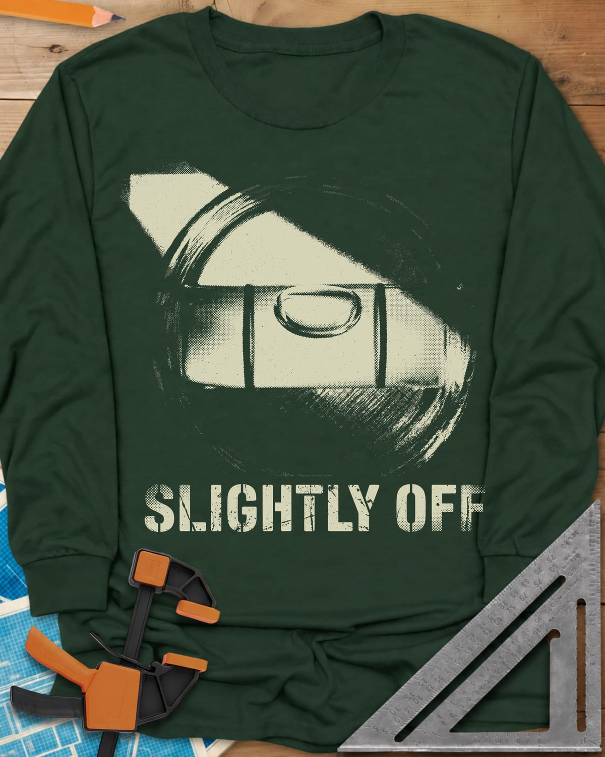 Slightly Off Level long sleeve shirt in Forest Green, a tilted spirit level and its bubble vial in grainy halftone