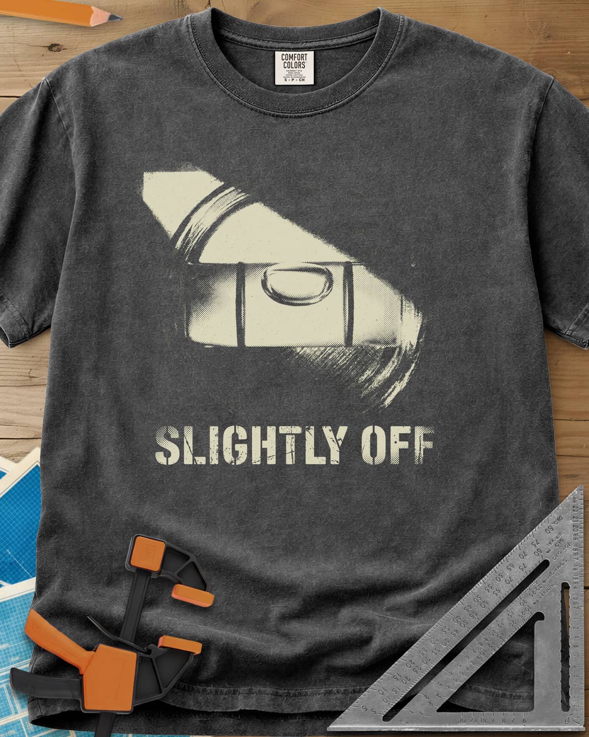Slightly Off Level heavyweight tee in Pepper, a tilted spirit level and its bubble vial in grainy halftone