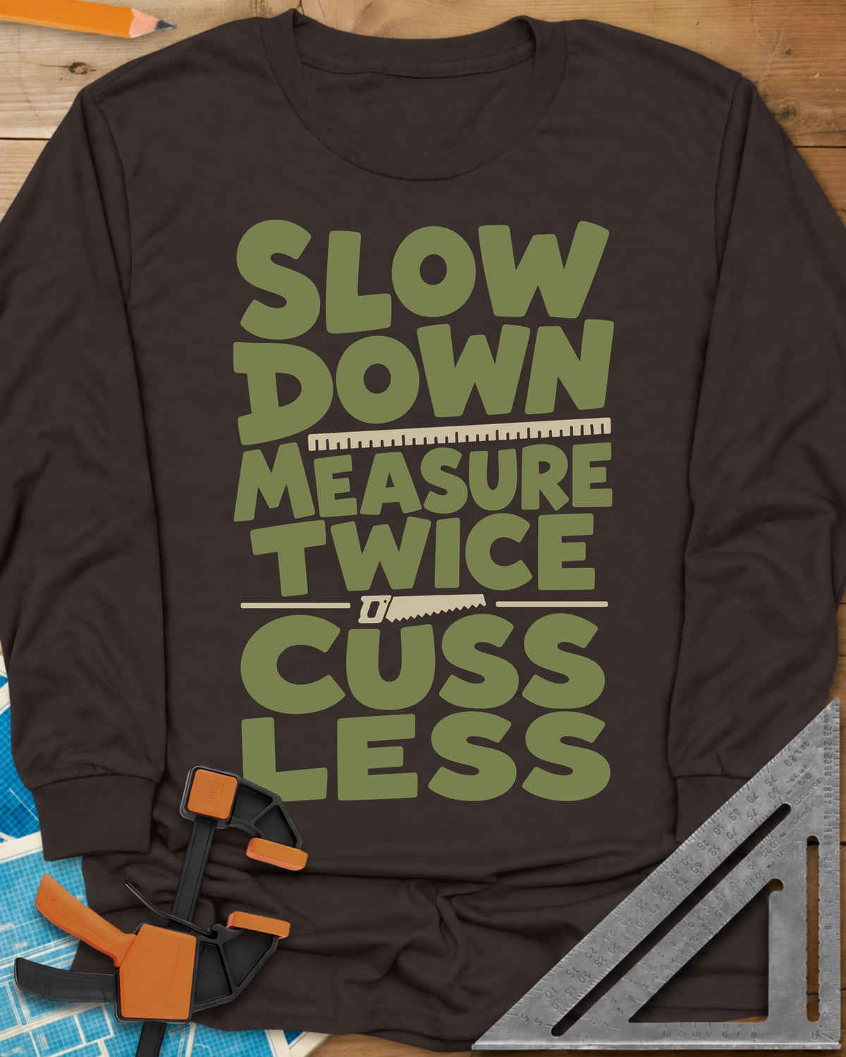 Slow Down Measure Twice long sleeve shirt in Dark Chocolate, stacked green letters with a ruler and a small handsaw between