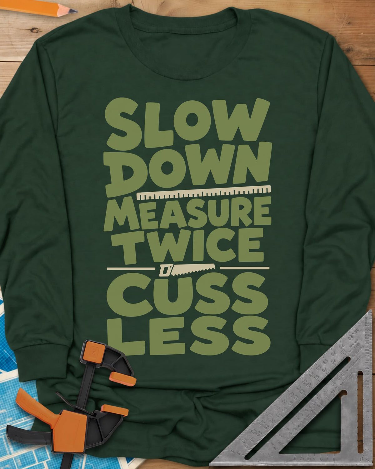 Slow Down Measure Twice long sleeve shirt in Forest Green, stacked green letters with a ruler and a small handsaw between