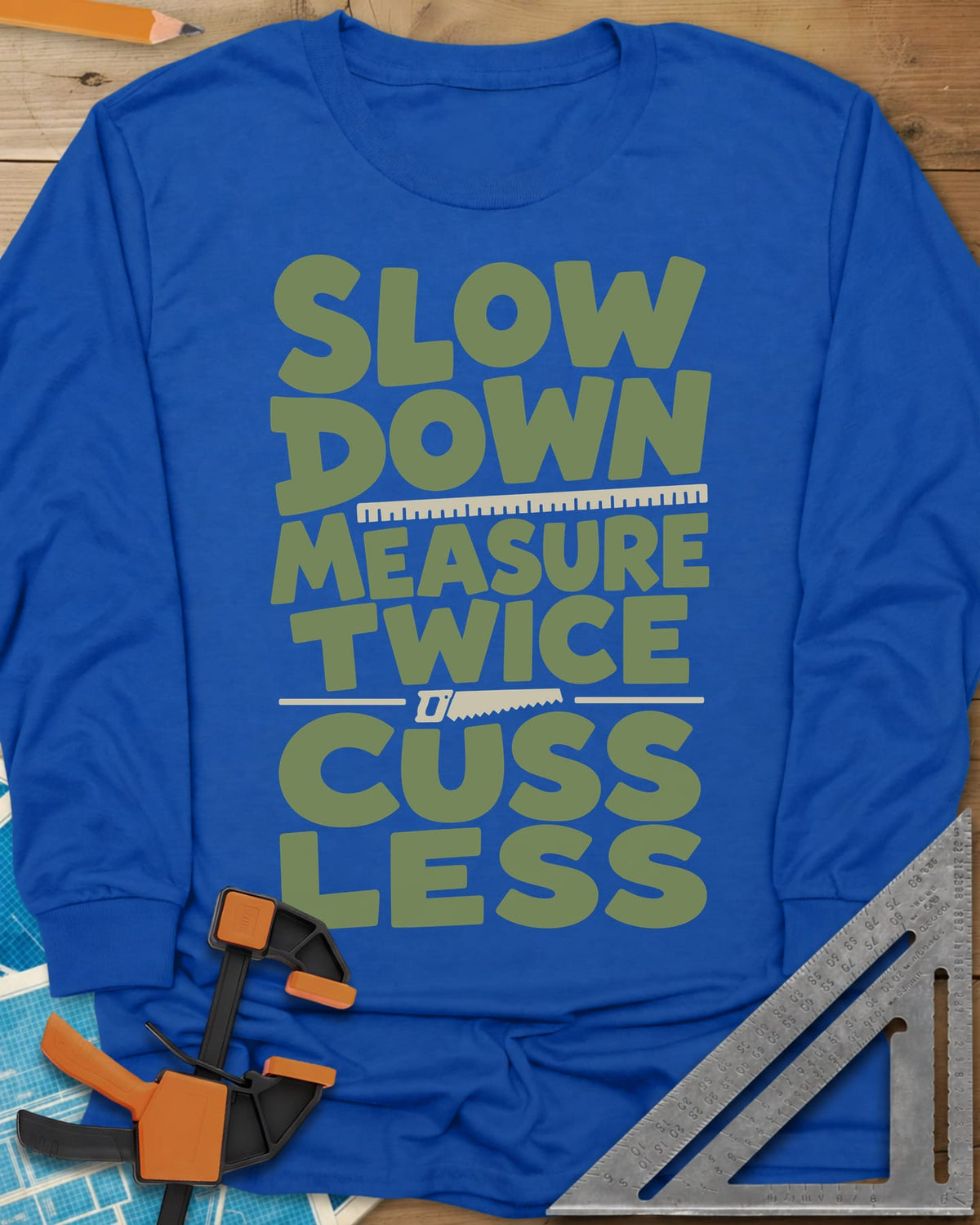 Slow Down Measure Twice long sleeve shirt in Royal, stacked green letters with a ruler and a small handsaw between lines