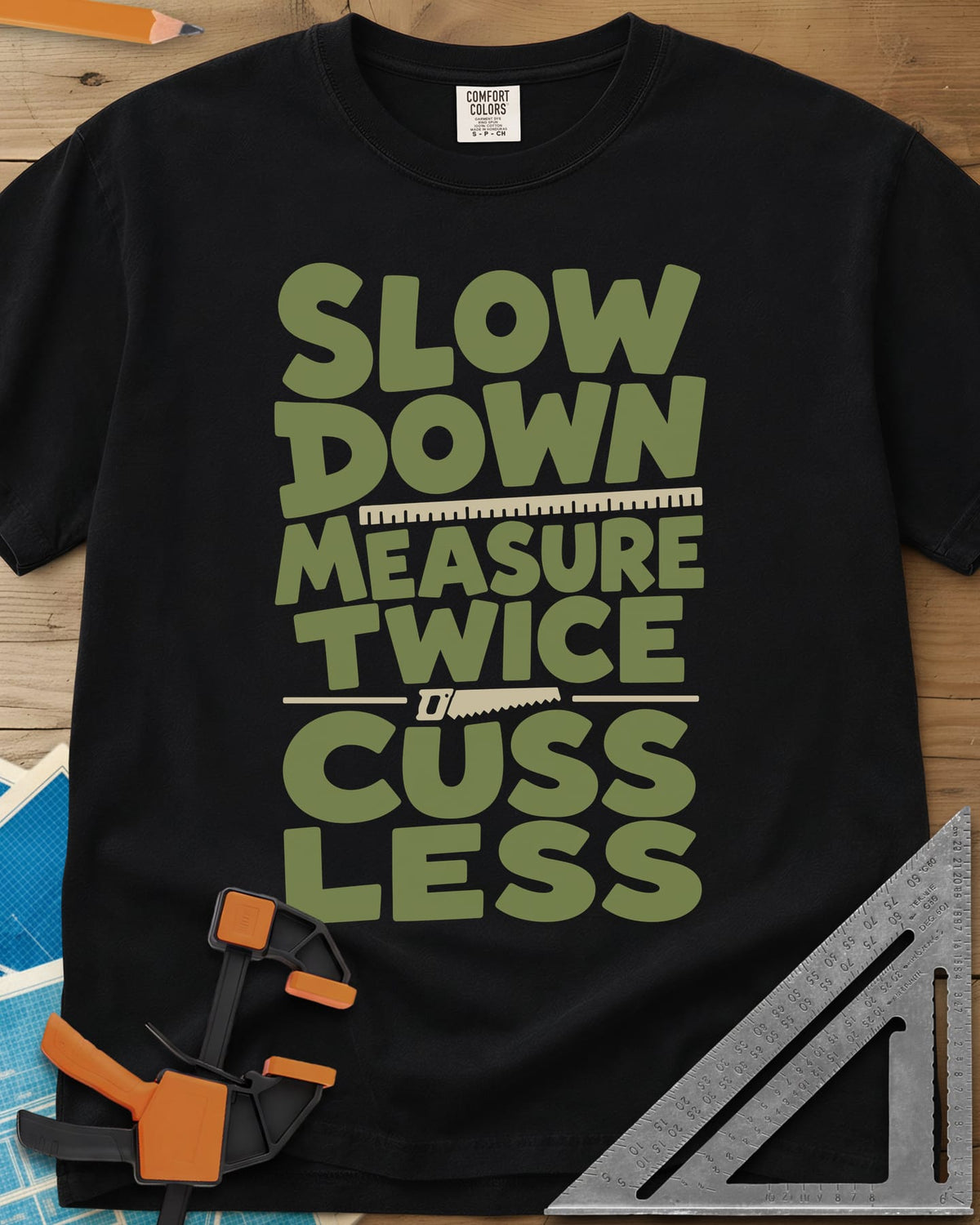 Slow Down Measure Twice heavyweight tee in Black, stacked green letters with a ruler and a small handsaw between lines