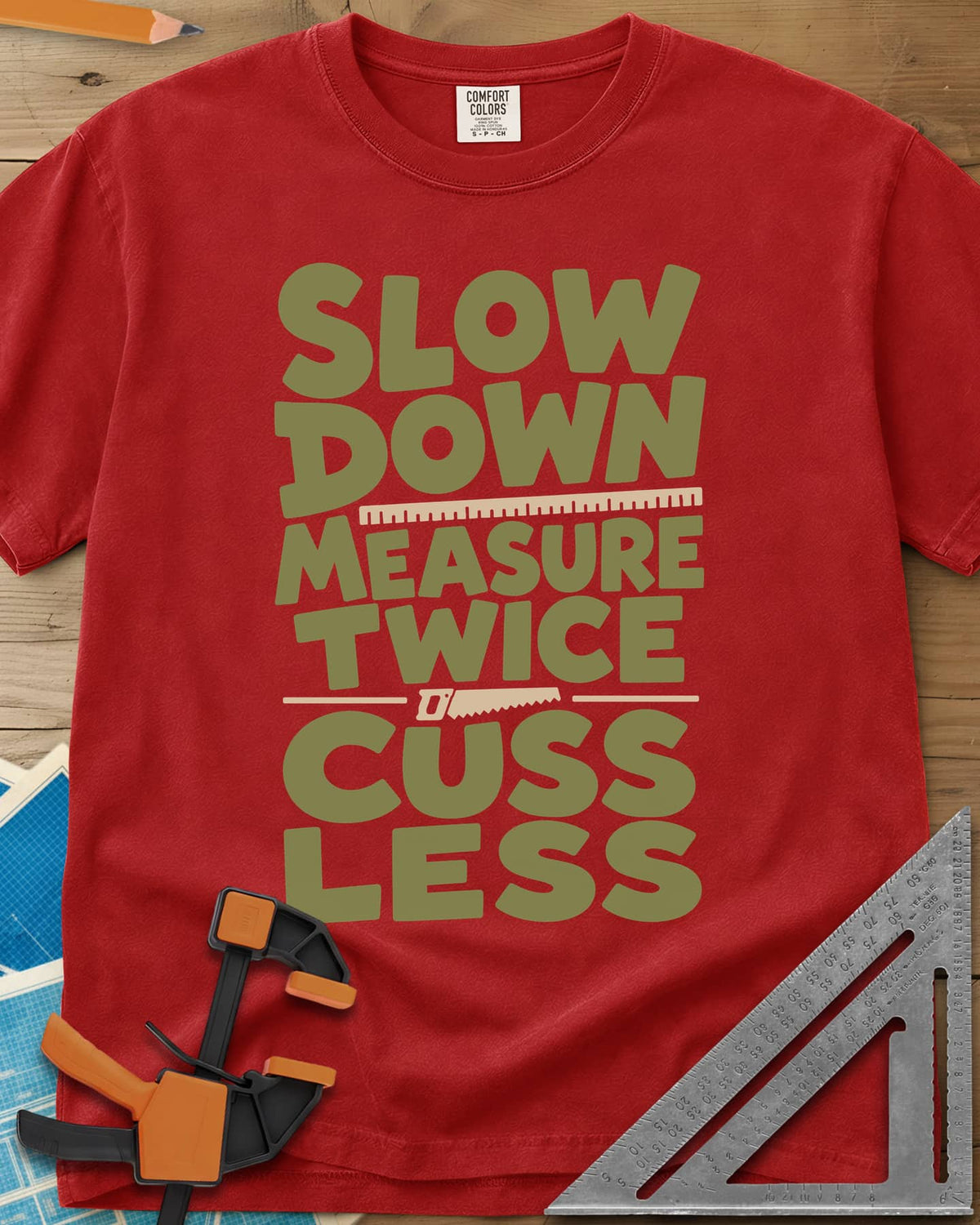 Slow Down Measure Twice heavyweight tee in Red, stacked green letters with a ruler and a small handsaw between lines