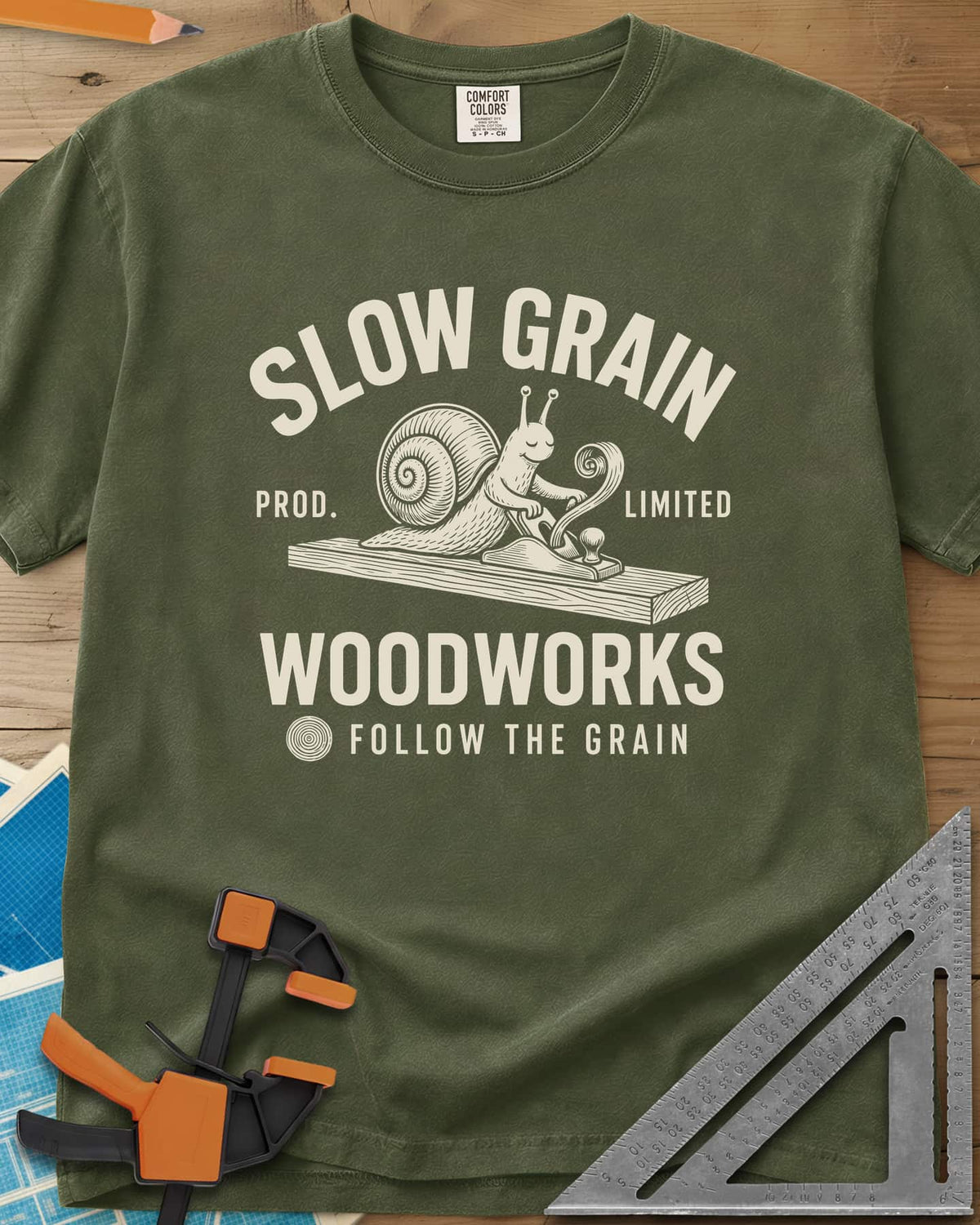 Slow Grain heavyweight tee in Hemp, a smiling snail planing a plank, one curl of shaving rising