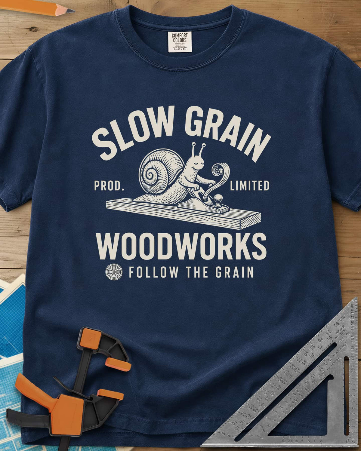 Slow Grain heavyweight tee in Navy, a smiling snail planing a plank, one curl of shaving rising