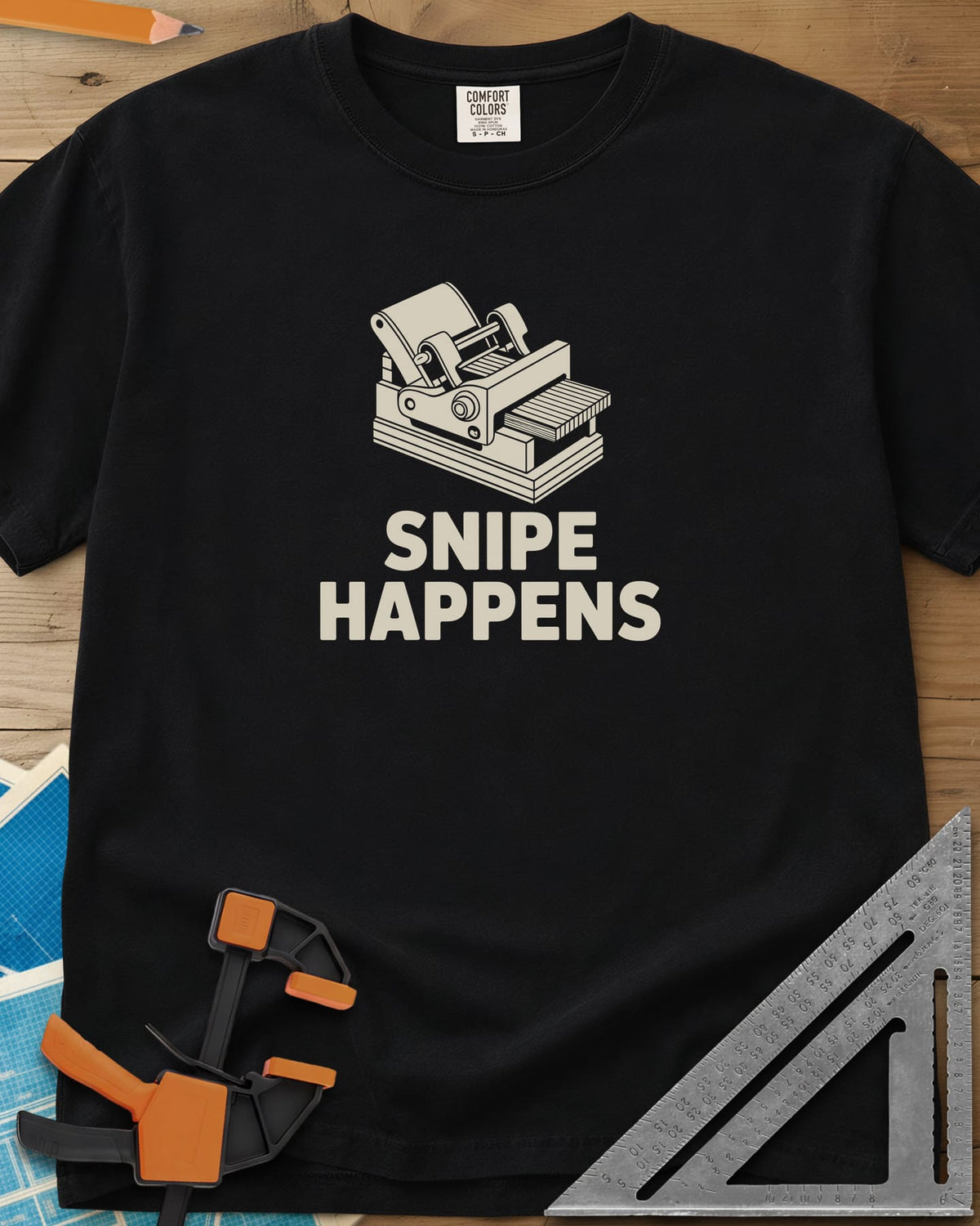 Snipe Happens heavyweight tee in Black, a thickness planer line drawing with boards at the outfeed