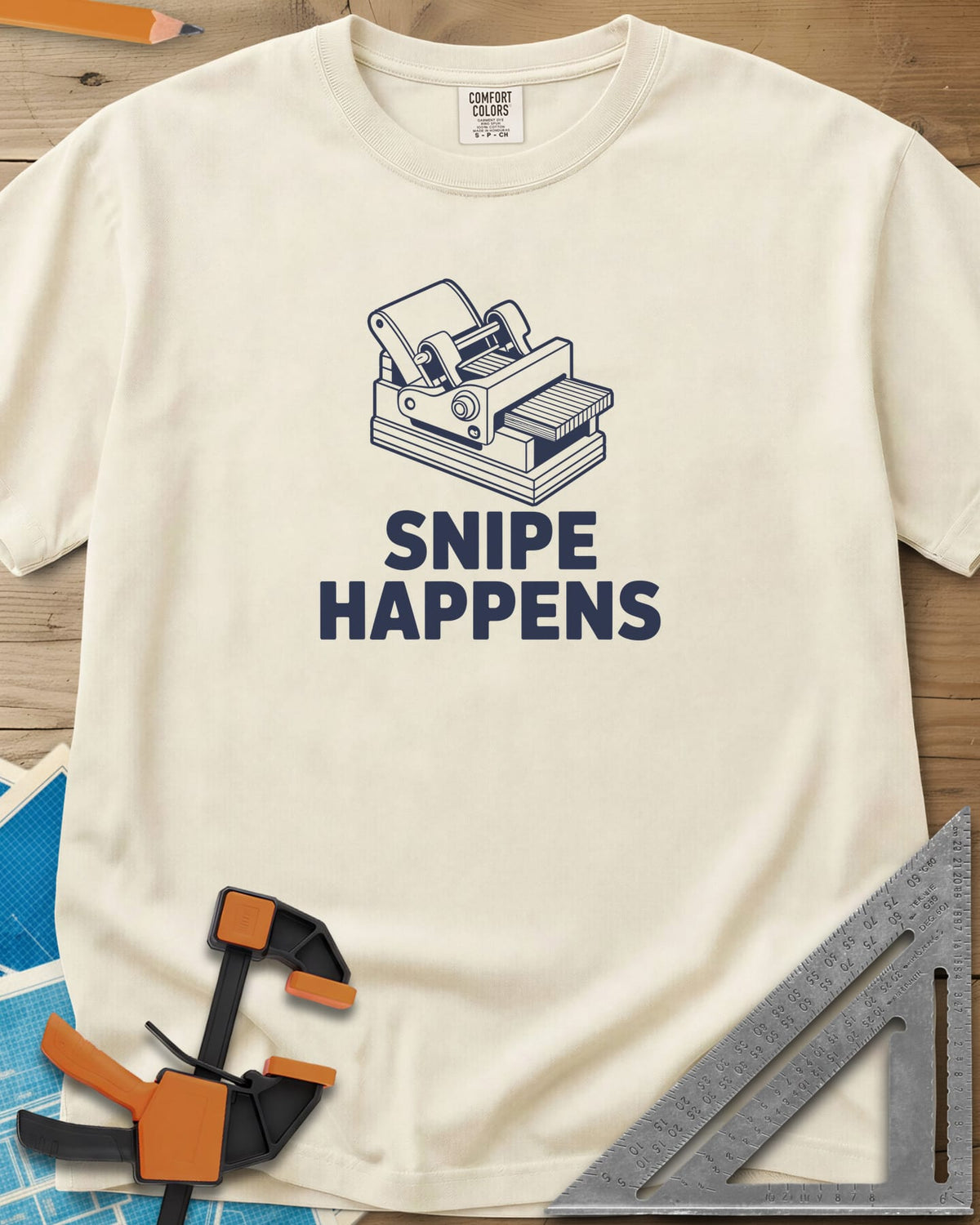 Snipe Happens heavyweight tee in Ivory, a thickness planer line drawing with boards at the outfeed