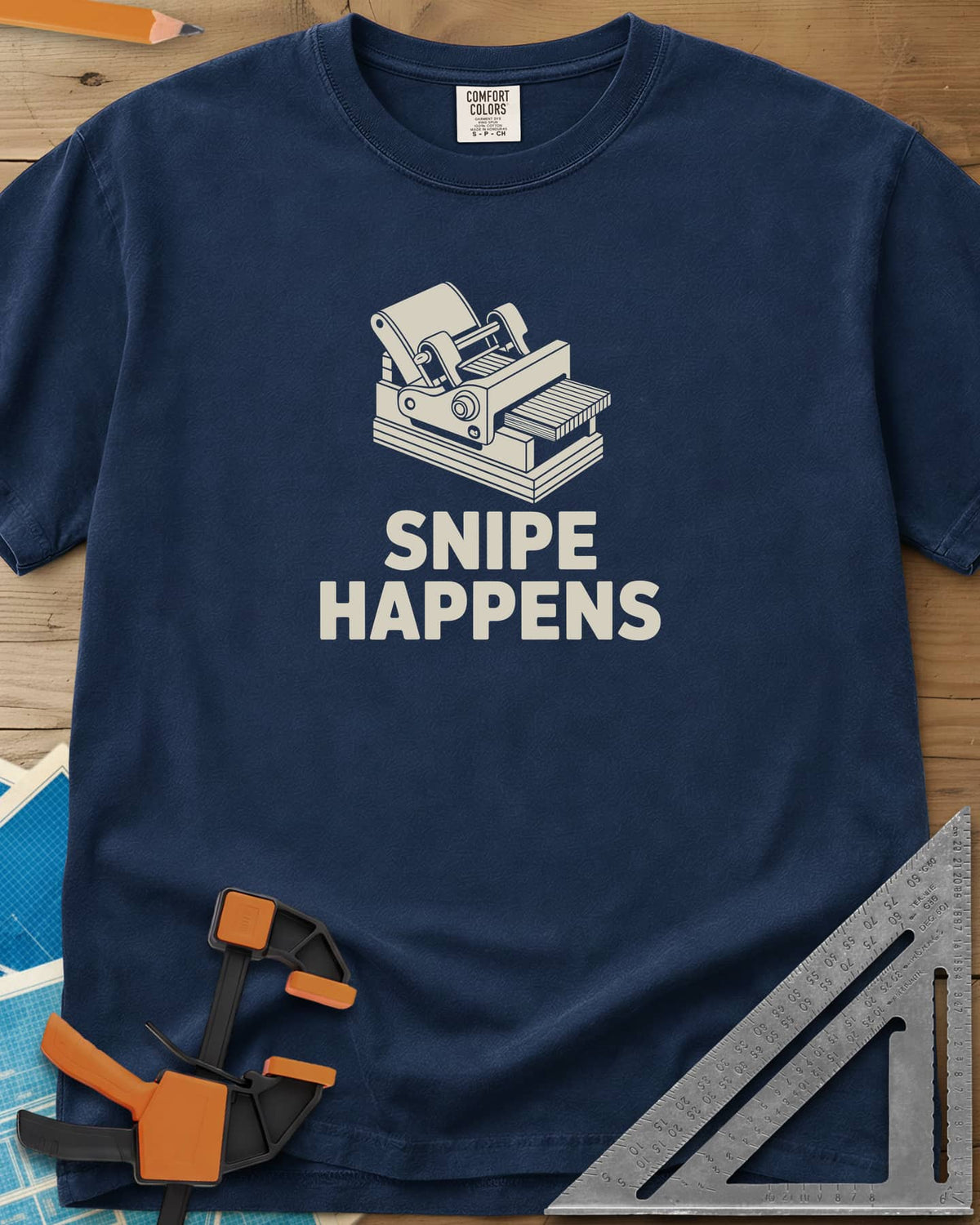 Snipe Happens heavyweight tee in Navy, a thickness planer line drawing with boards at the outfeed