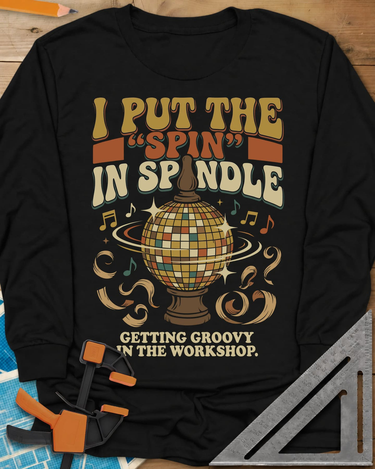 Spin in Spindle long sleeve shirt in Black, a disco ball on a turned wooden base with notes and shavings