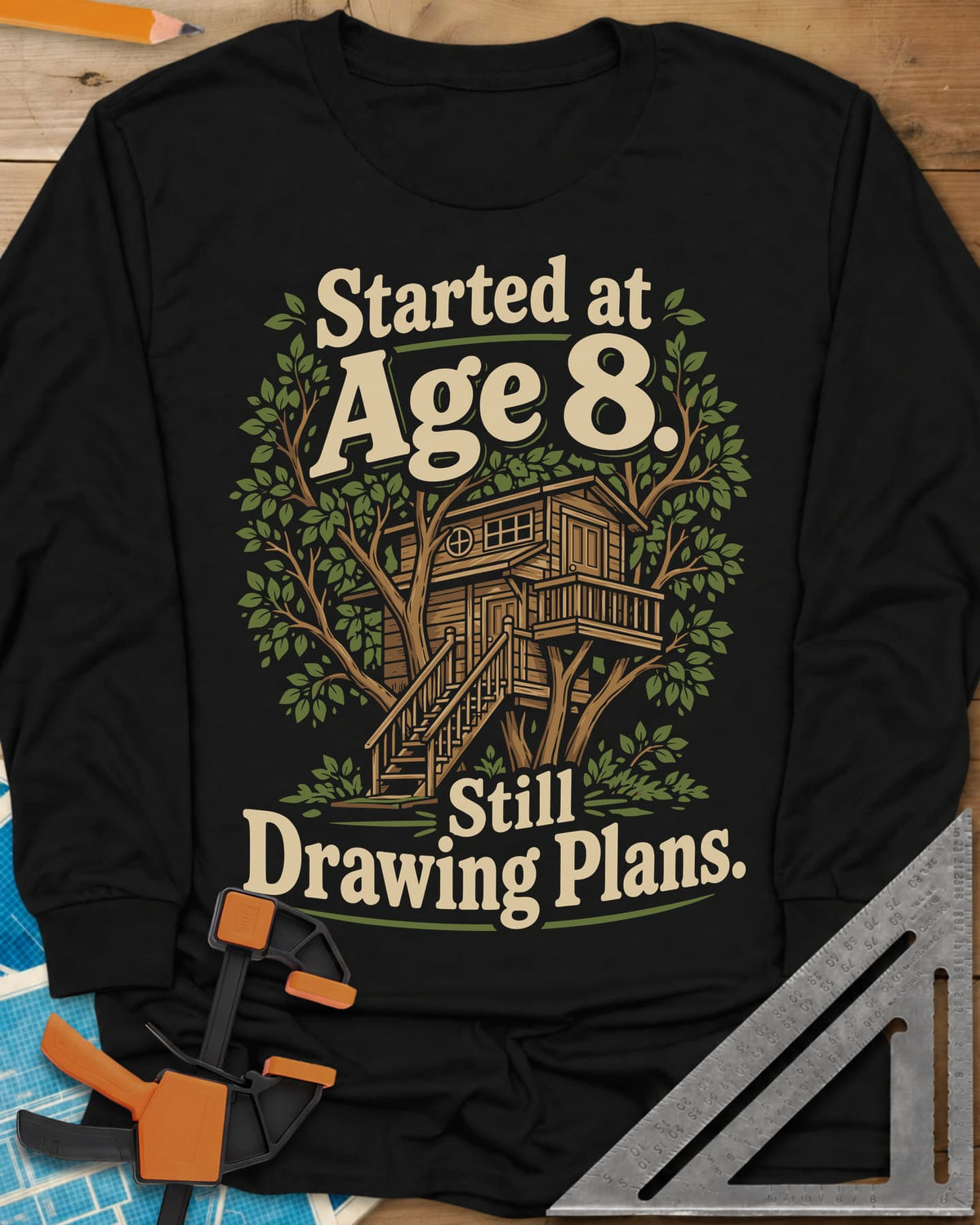 Started At Age 8 long sleeve shirt in Black, a wooden treehouse with a deck and stairs among green leaves