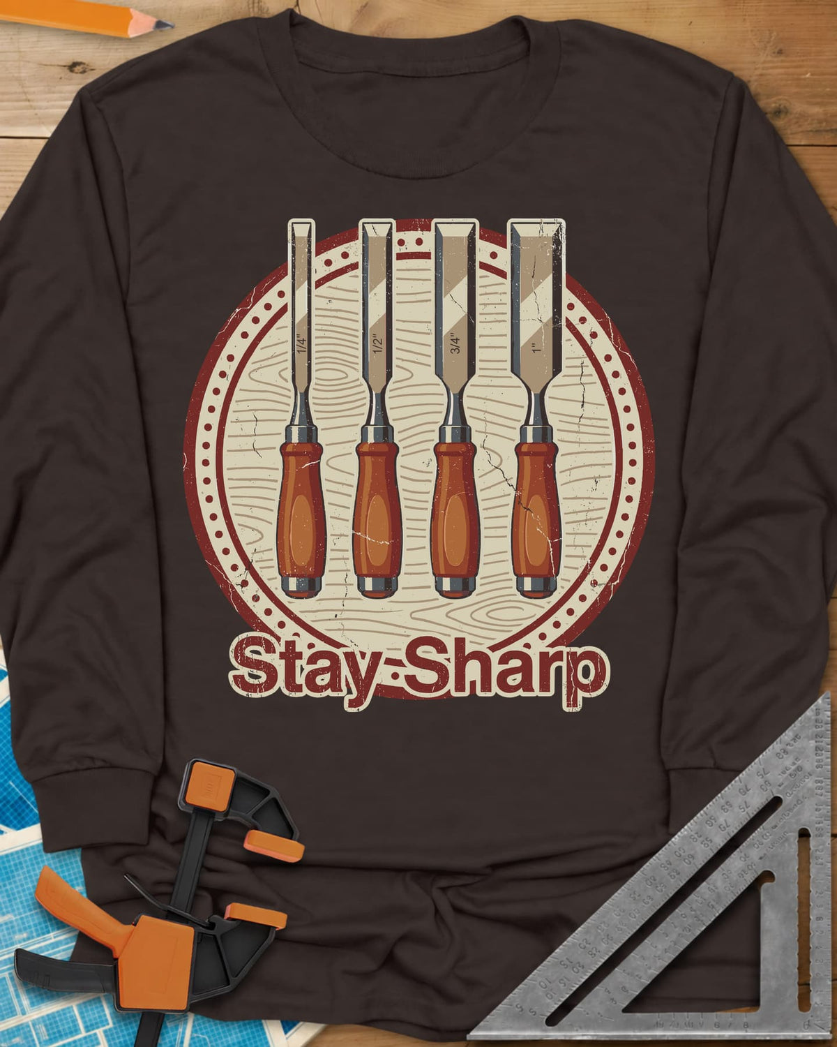 Stay Sharp long sleeve shirt in Dark Chocolate, four wood chisels on a round wood-grain badge