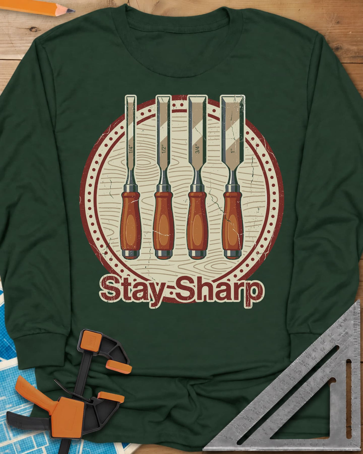 Stay Sharp long sleeve shirt in Forest Green, four wood chisels on a round wood-grain badge