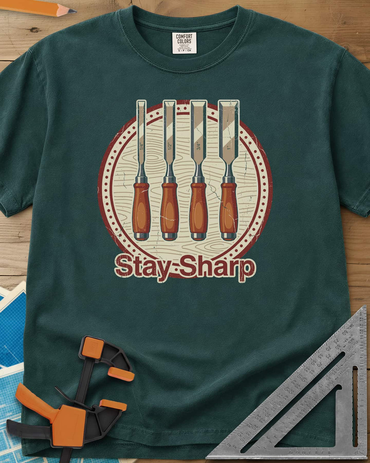 Stay Sharp heavyweight tee in Blue Spruce, four wood chisels on a round wood-grain badge