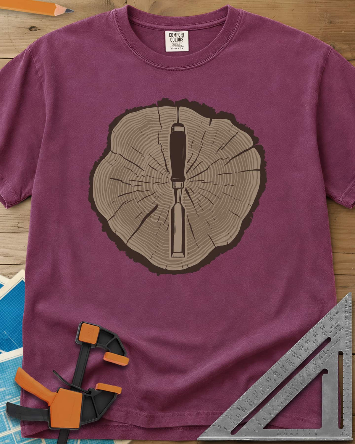 Stump & Chisel heavyweight tee in Berry, a wood chisel set in the middle of a cracked tree-ring slice