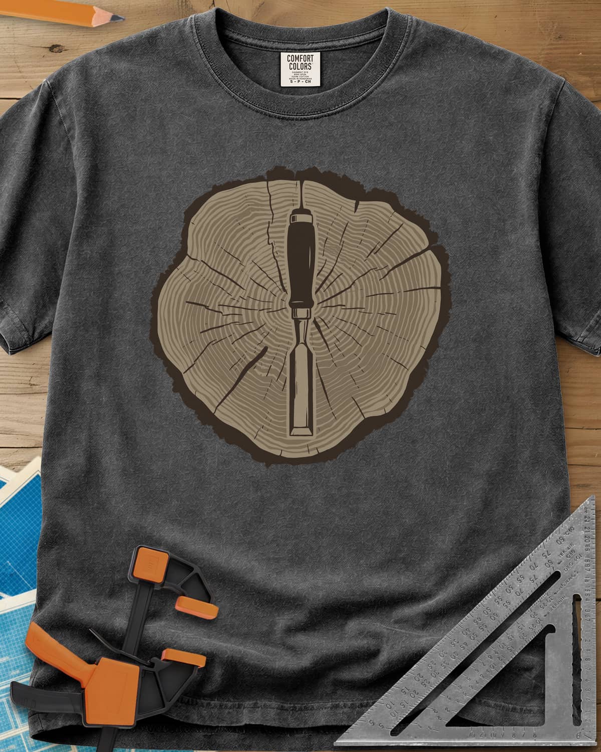 Stump & Chisel heavyweight tee in Pepper, a wood chisel set in the middle of a cracked tree-ring slice