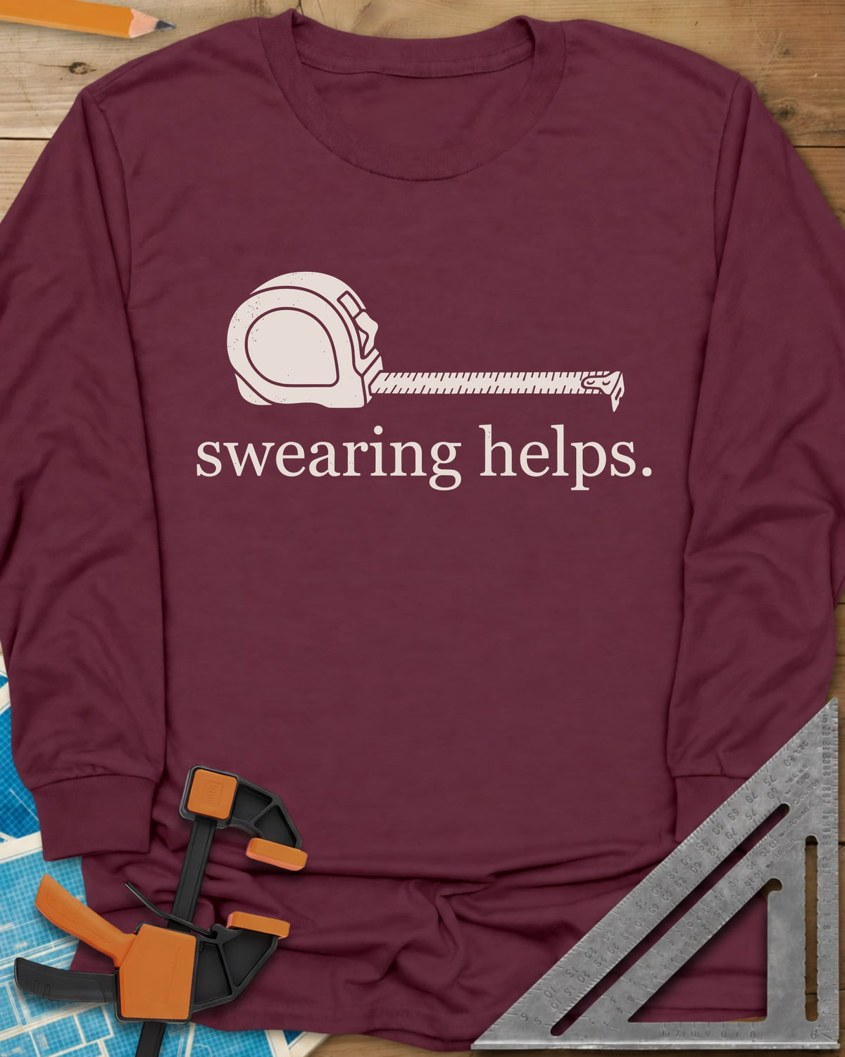 Swearing Helps long sleeve shirt in Maroon, a tape measure with its blade pulled out above small lowercase type