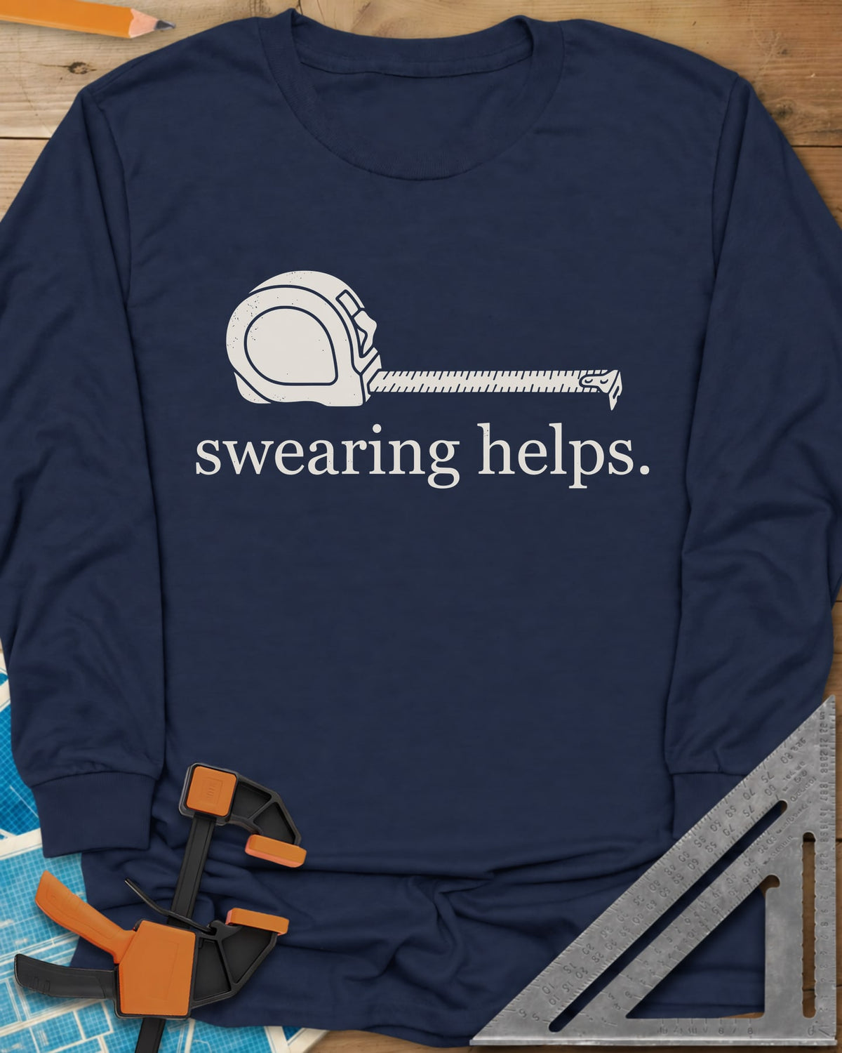 Swearing Helps long sleeve shirt in Navy, a tape measure with its blade pulled out above small lowercase type