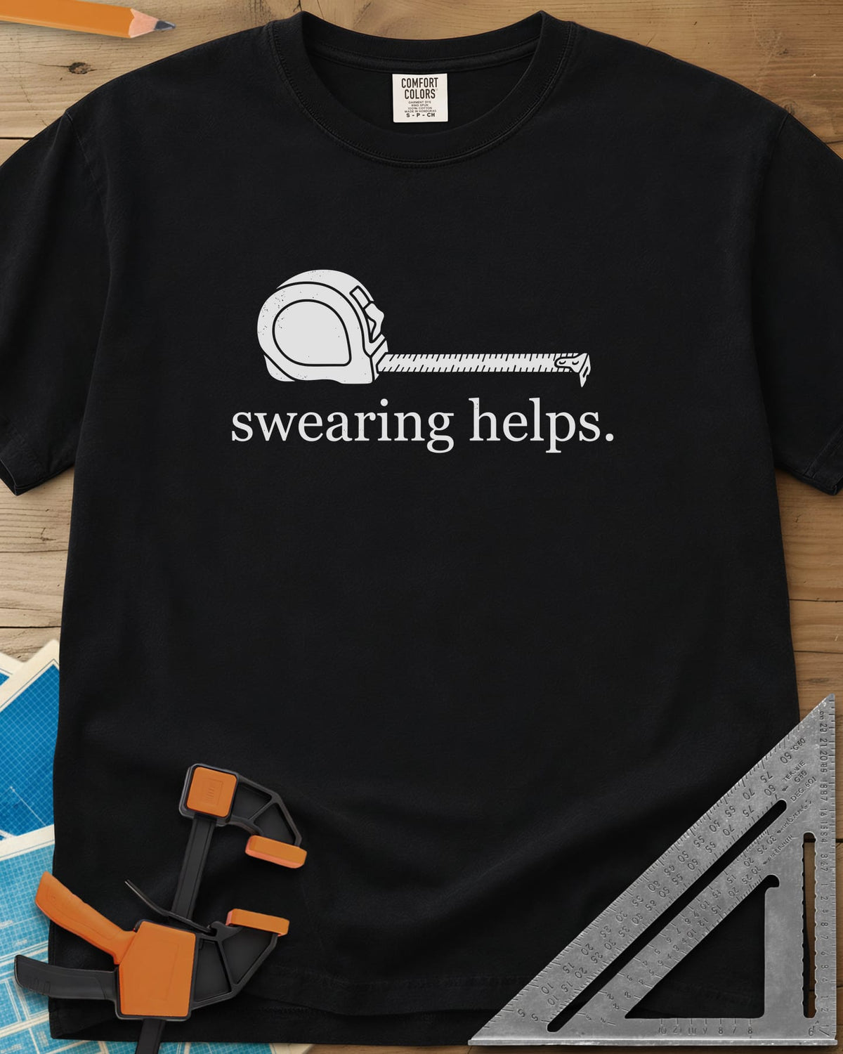 Swearing Helps heavyweight tee in Black, a tape measure with its blade pulled out above small lowercase type