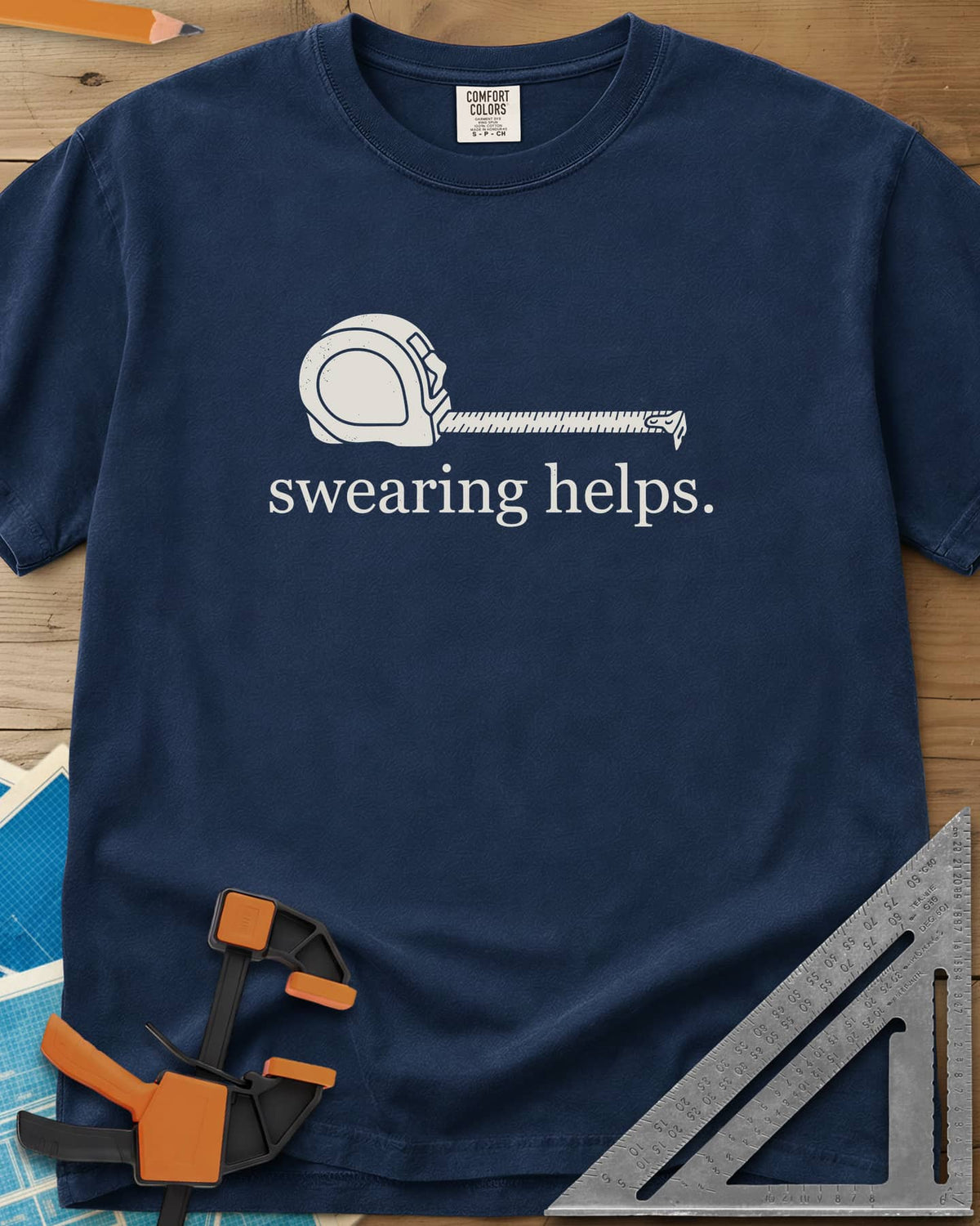 Swearing Helps heavyweight tee in Navy, a tape measure with its blade pulled out above small lowercase type