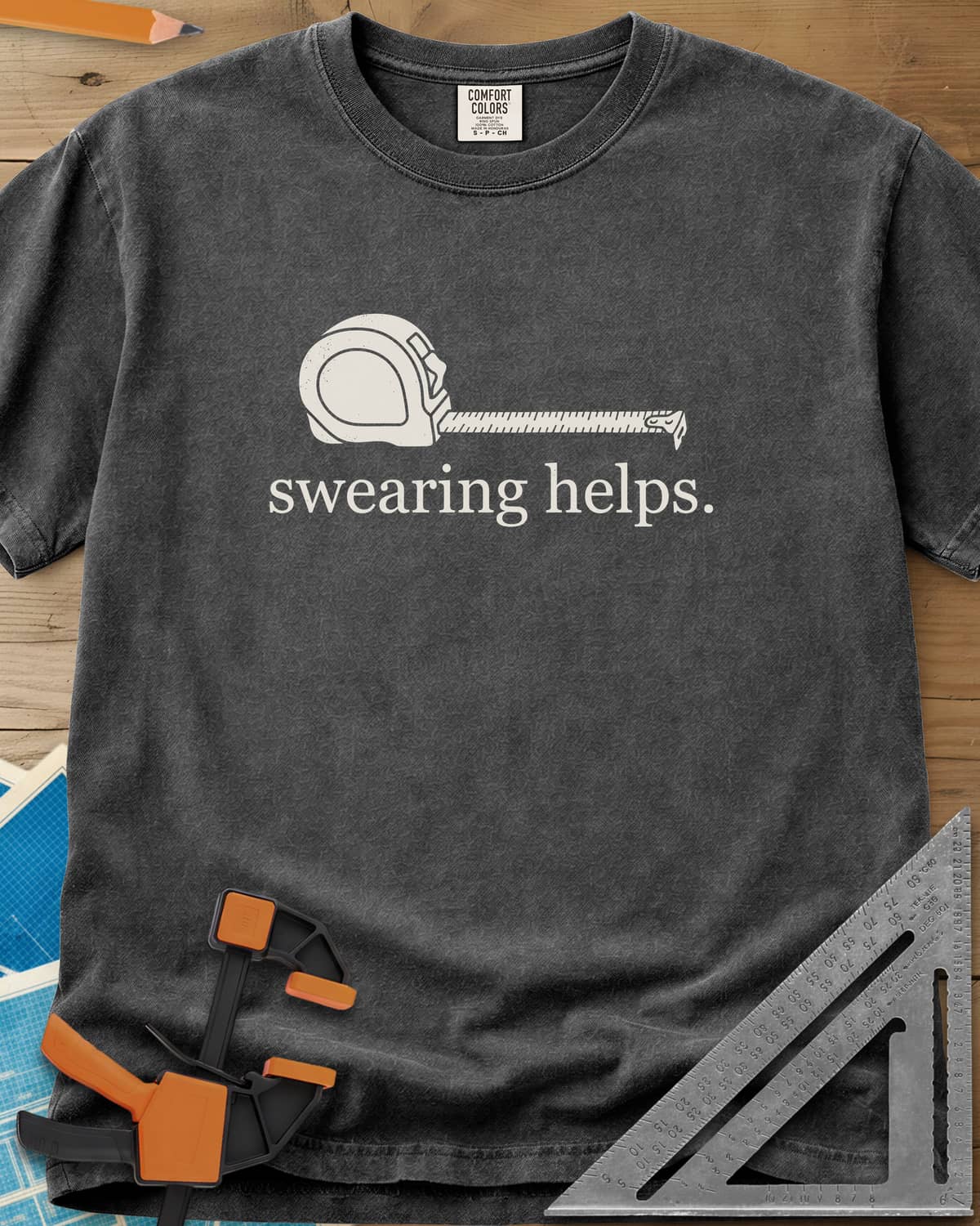 Swearing Helps heavyweight tee in Pepper, a tape measure with its blade pulled out above small lowercase type