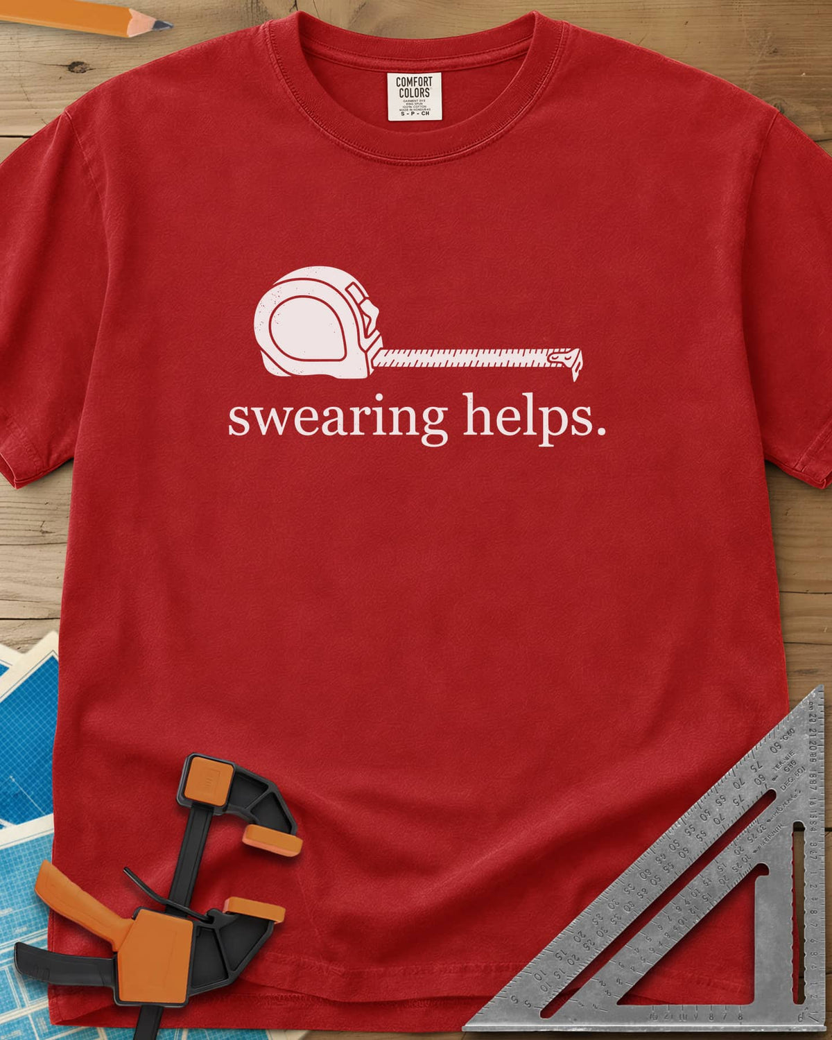 Swearing Helps heavyweight tee in Red, a tape measure with its blade pulled out above small lowercase type
