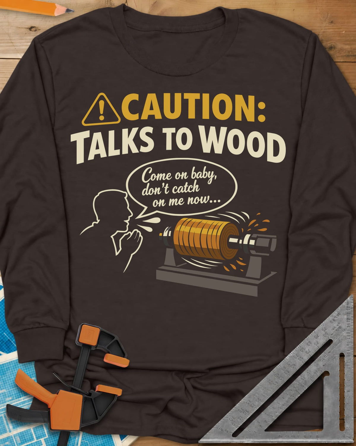 Talks to Wood long sleeve shirt in Dark Chocolate, a man in outline coaxing a spinning wood blank on a lathe