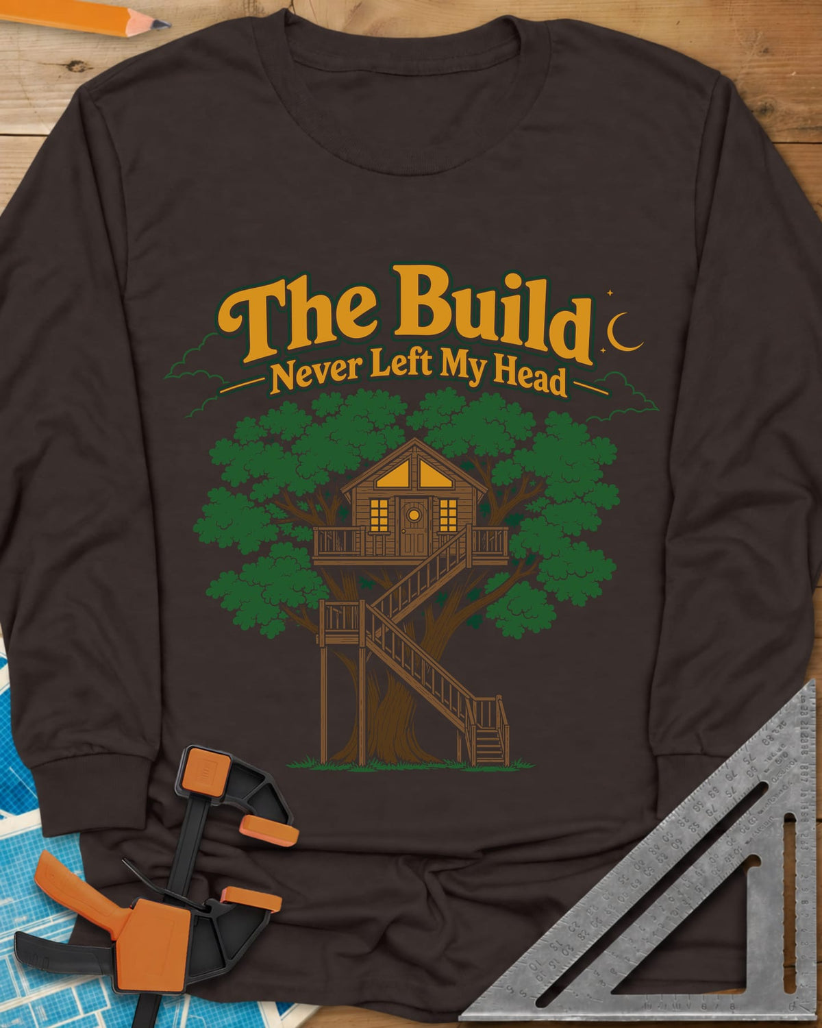 The Build Never Left My Head long sleeve shirt in Dark Chocolate, a glowing treehouse in a big oak under a crescent moon