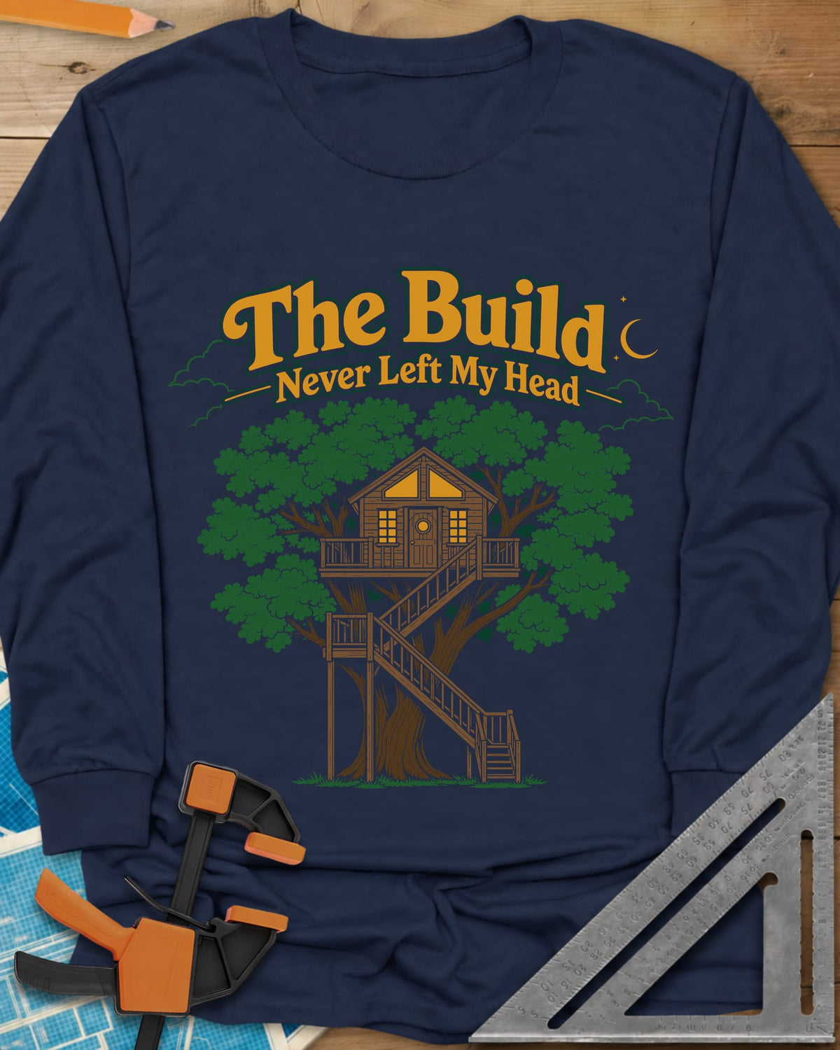 The Build Never Left My Head long sleeve shirt in Navy, a glowing treehouse in a big oak under a crescent moon