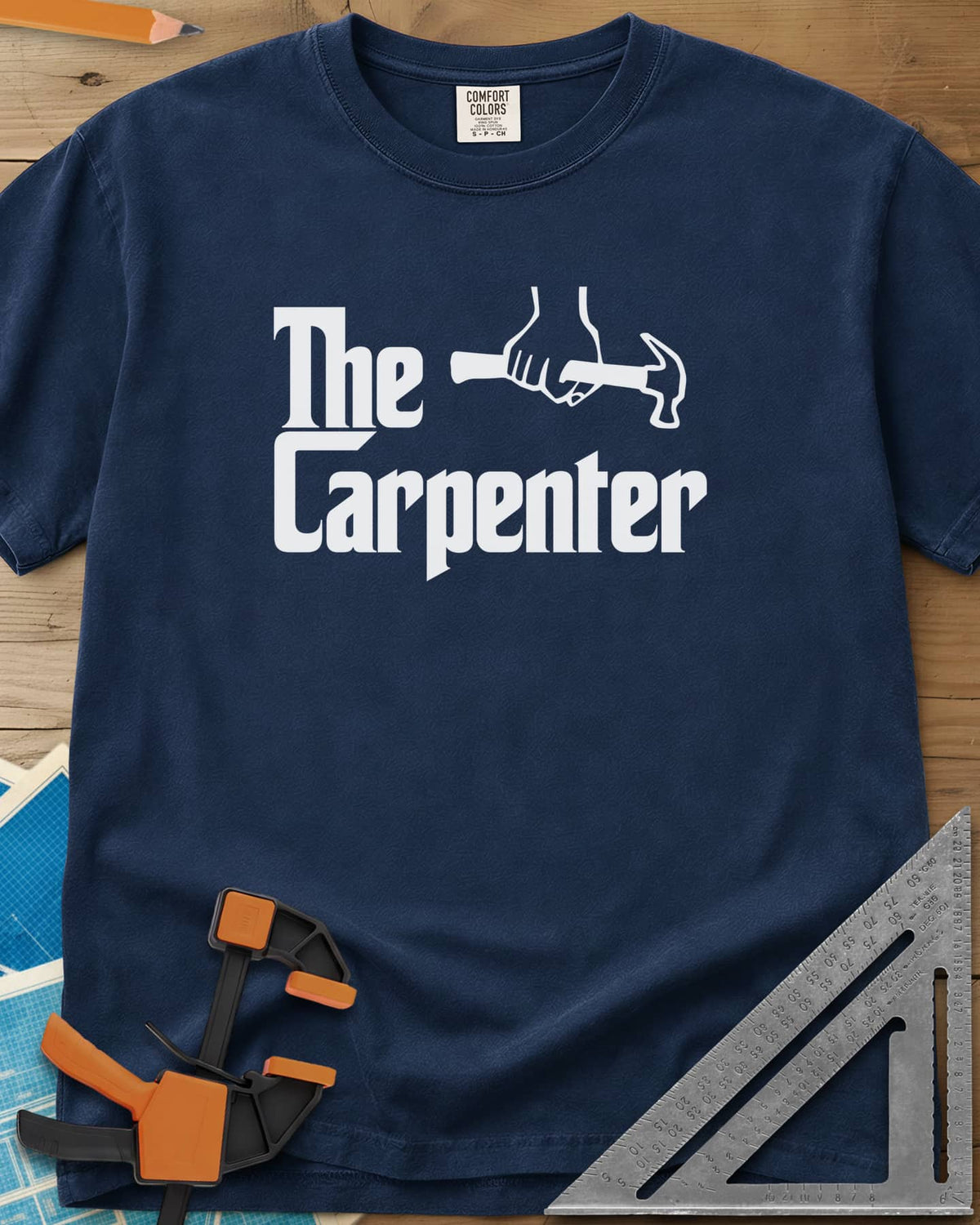 The Carpenter heavyweight tee in Navy, film-poster style lettering with a fist gripping a hammer