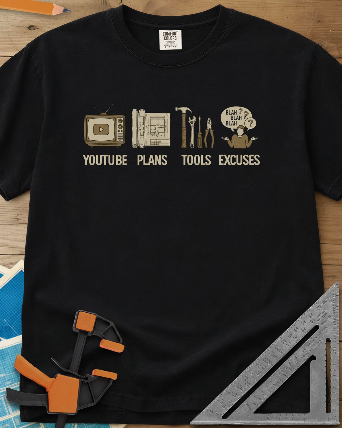 The DIY Loop heavyweight tee in Black, a retro TV, rolled plans, hand tools and a shrugging figure