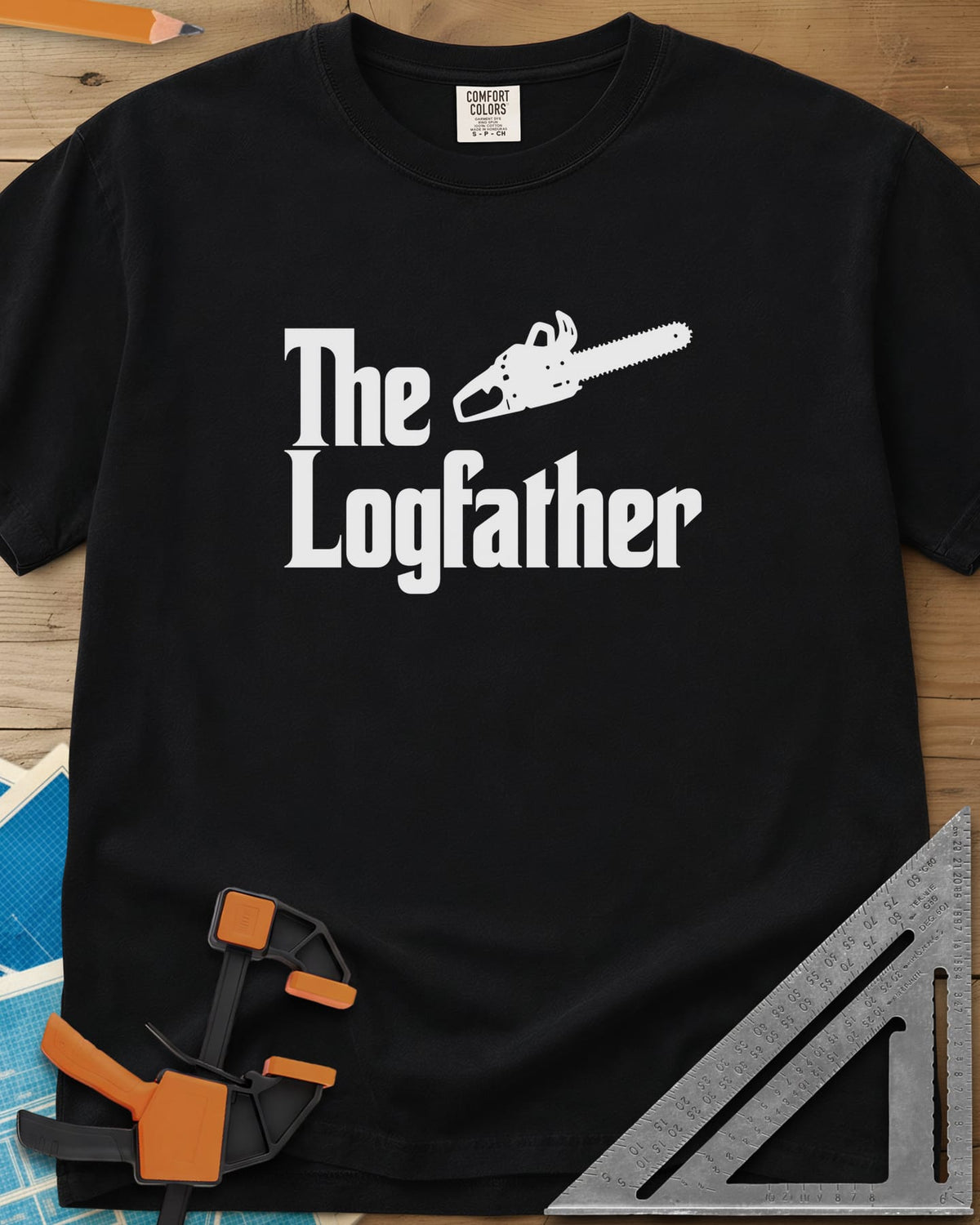 The Logfather heavyweight tee in Black, serif lettering with a chainsaw beside the word The