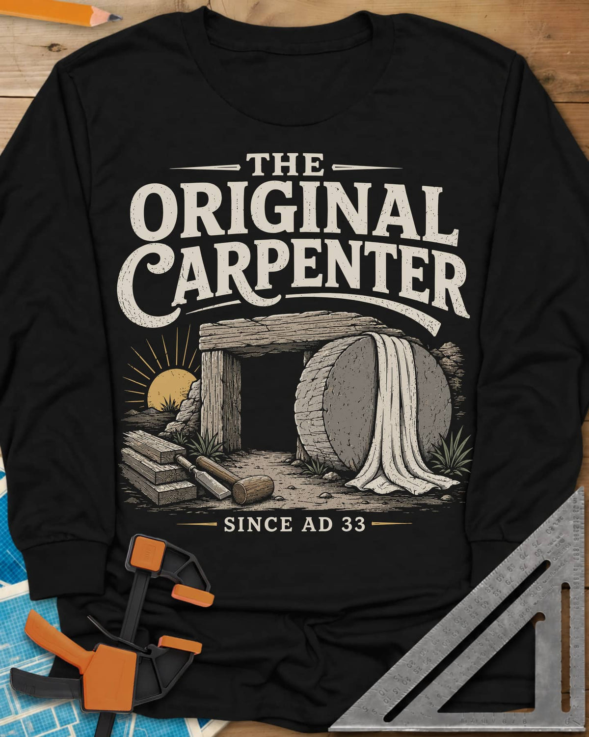 The Original Carpenter long sleeve shirt in Black, an empty tomb at sunrise with planks, a mallet and a chisel