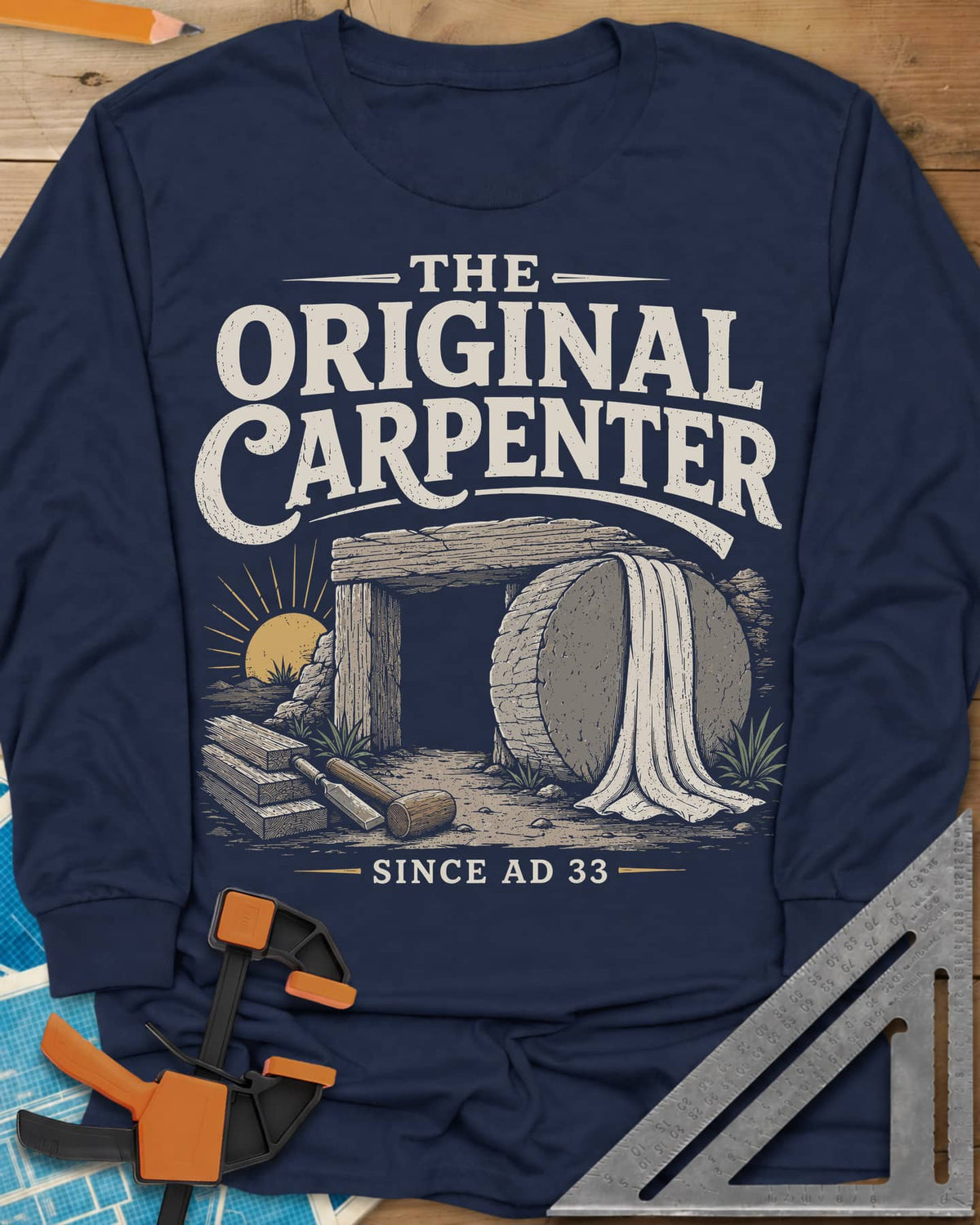 The Original Carpenter long sleeve shirt in Navy, an empty tomb at sunrise with planks, a mallet and a chisel