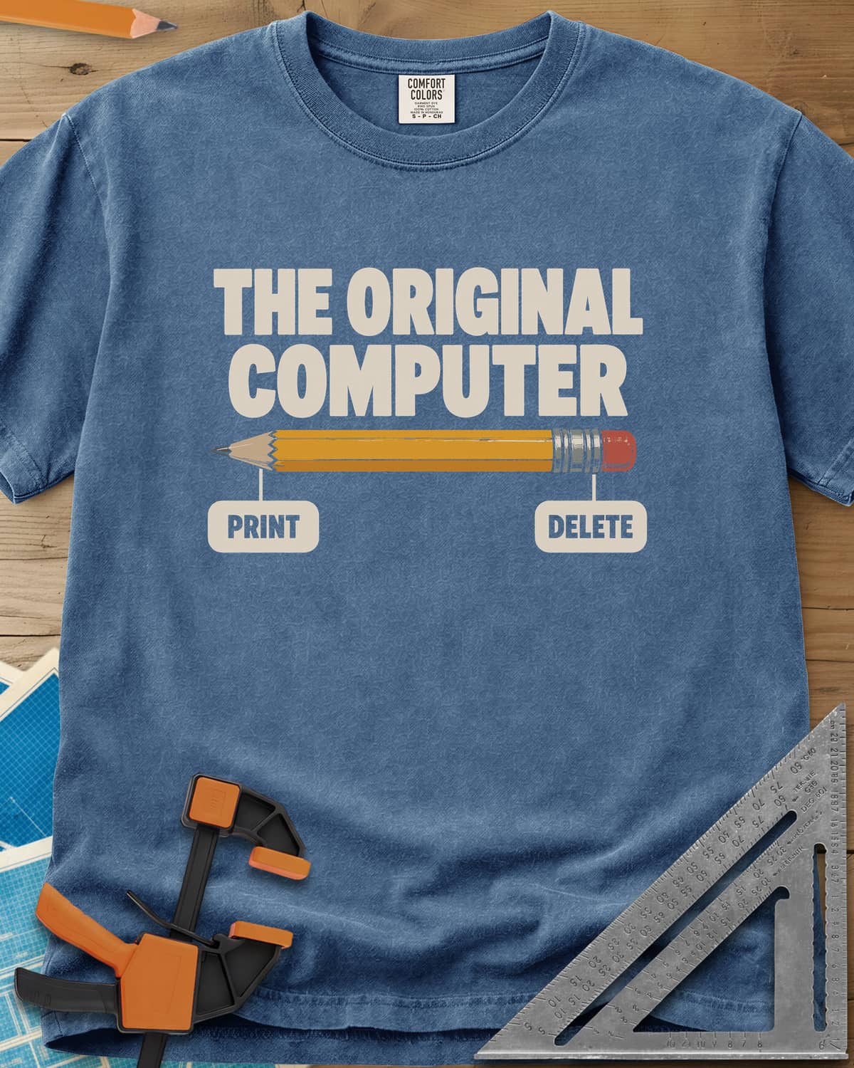 The Original Computer heavyweight tee in Blue Jean, a yellow pencil labeled PRINT at the point and DELETE at the eraser